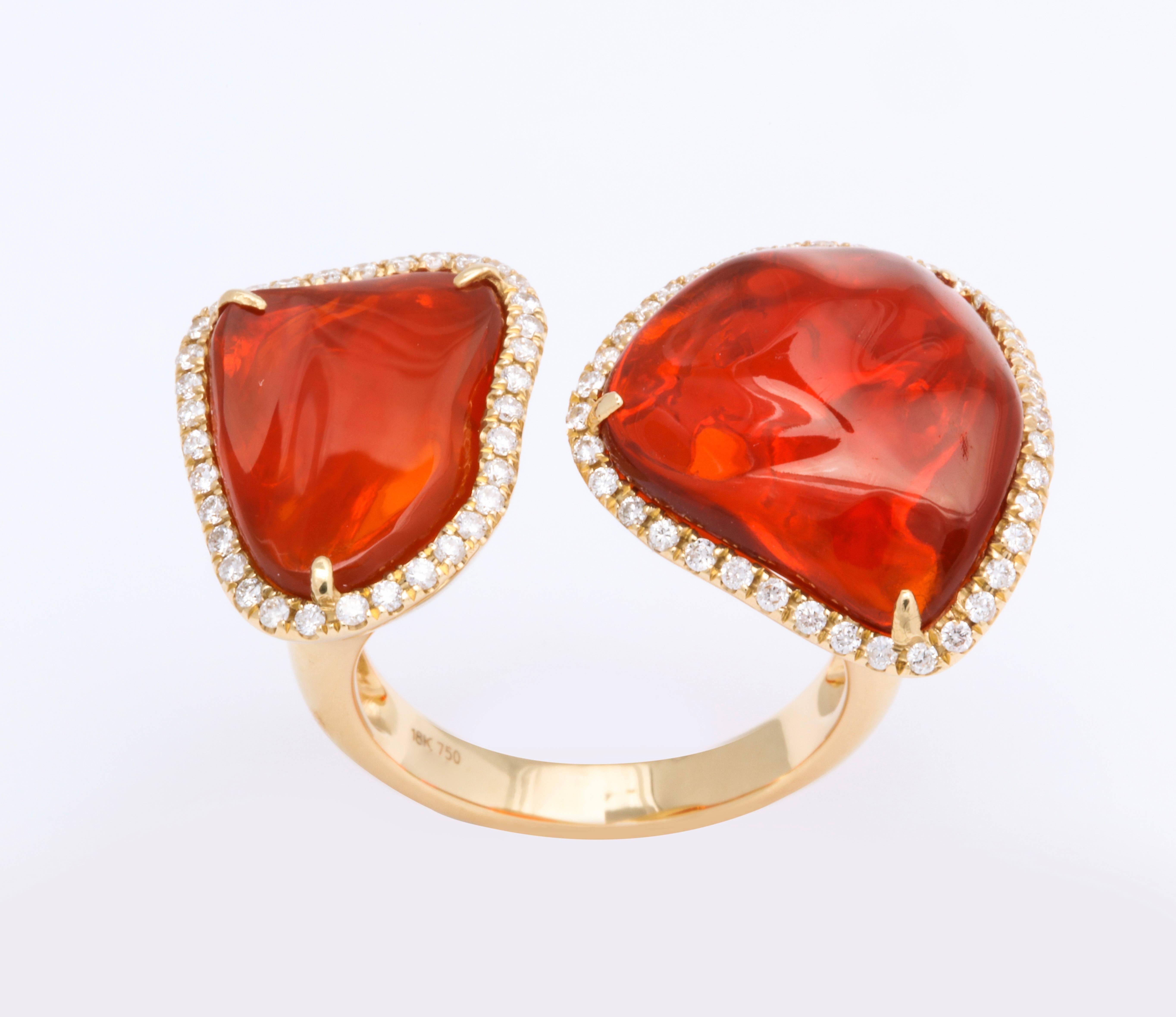 The twin ring is comprised of two baroque, free-form cut Mexican fire opals (2=8.10cts) encircled with diamonds (0.45cts) and set in 18kt yellow gold.  A one of a kind, bright vivid orange show stopper.  Size 6 1/2

Fire opals symbolize joy of the