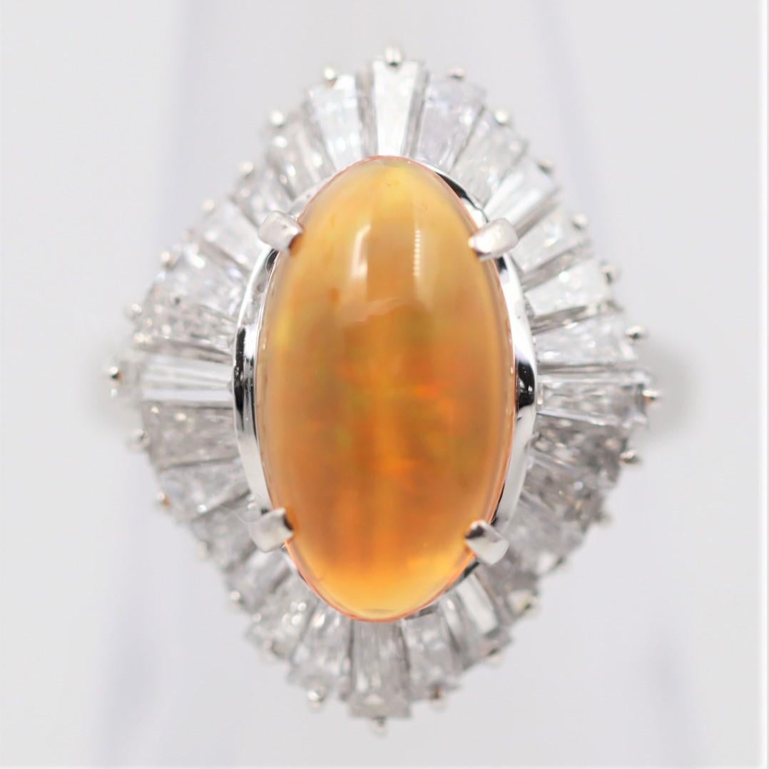 A lovely ballerina style ring featuring a 3.39 carat fire opal with great play-of-color. The opal has a rich orange body color along with flashes of green, orange, and red. It is accented by 2.40 carats of large baguette-cut diamonds set around the