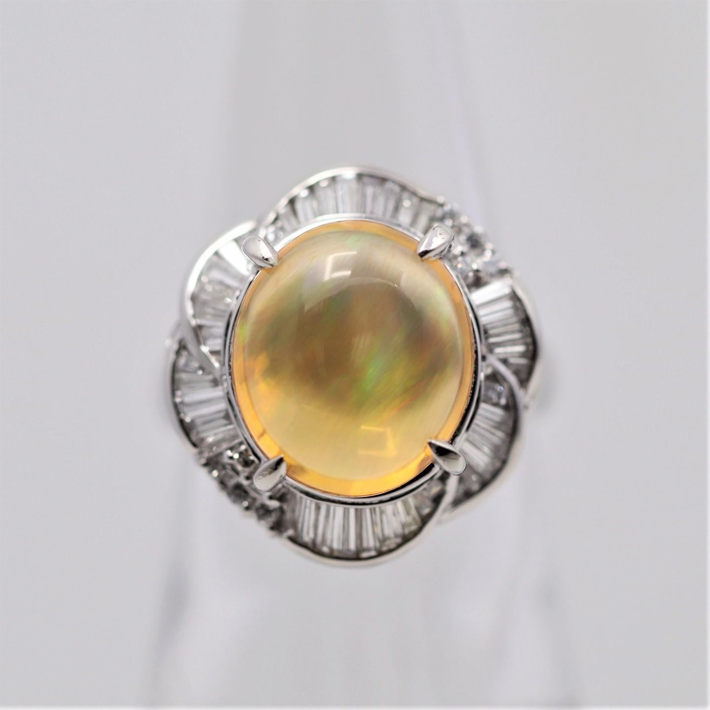 A superb fire opal from Mexico weighing 5.06 carats. It has excellent play of color as flashes of orange, green and blue. It is accented by 0.85 carats of diamonds set around it in a spiral pattern. Hand-fabricated in platinum and ready to be