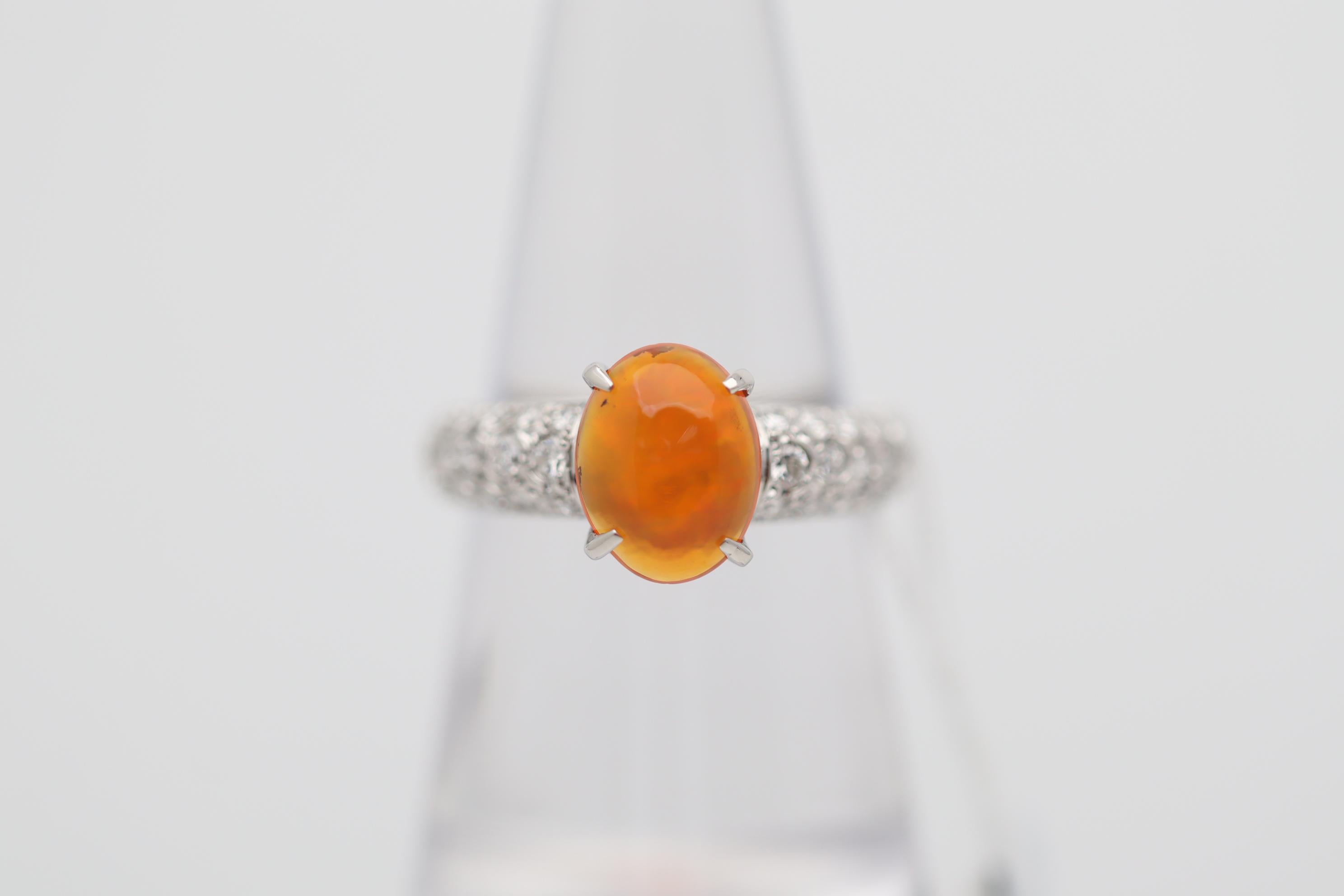 A very fine Mexican fire opal takes center stage of this platinum ring. The opal weighs 1.38 carats and has the ideal intense jelly orange color which is so desired. Adding to that the opal has great play of color as flashes of reds and oranges run