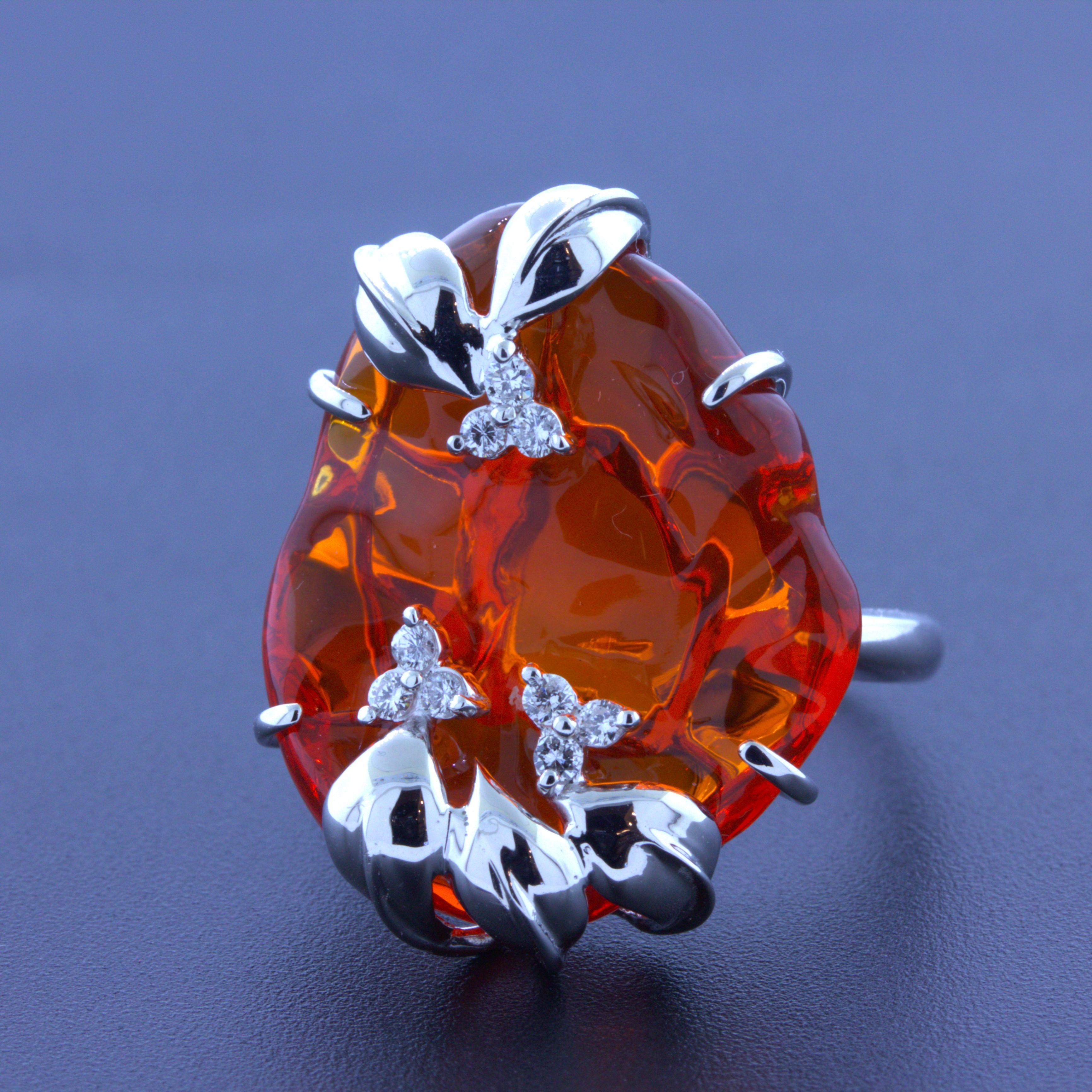 A unique and stylish 18k white gold ring featuring a large 18.25 carat Mexican fire opal! It has been hand-polished to a smooth free-form shape and has a rich and bright deep jelly orange color that is mesmerizing. It is completed by 0.17 carats of