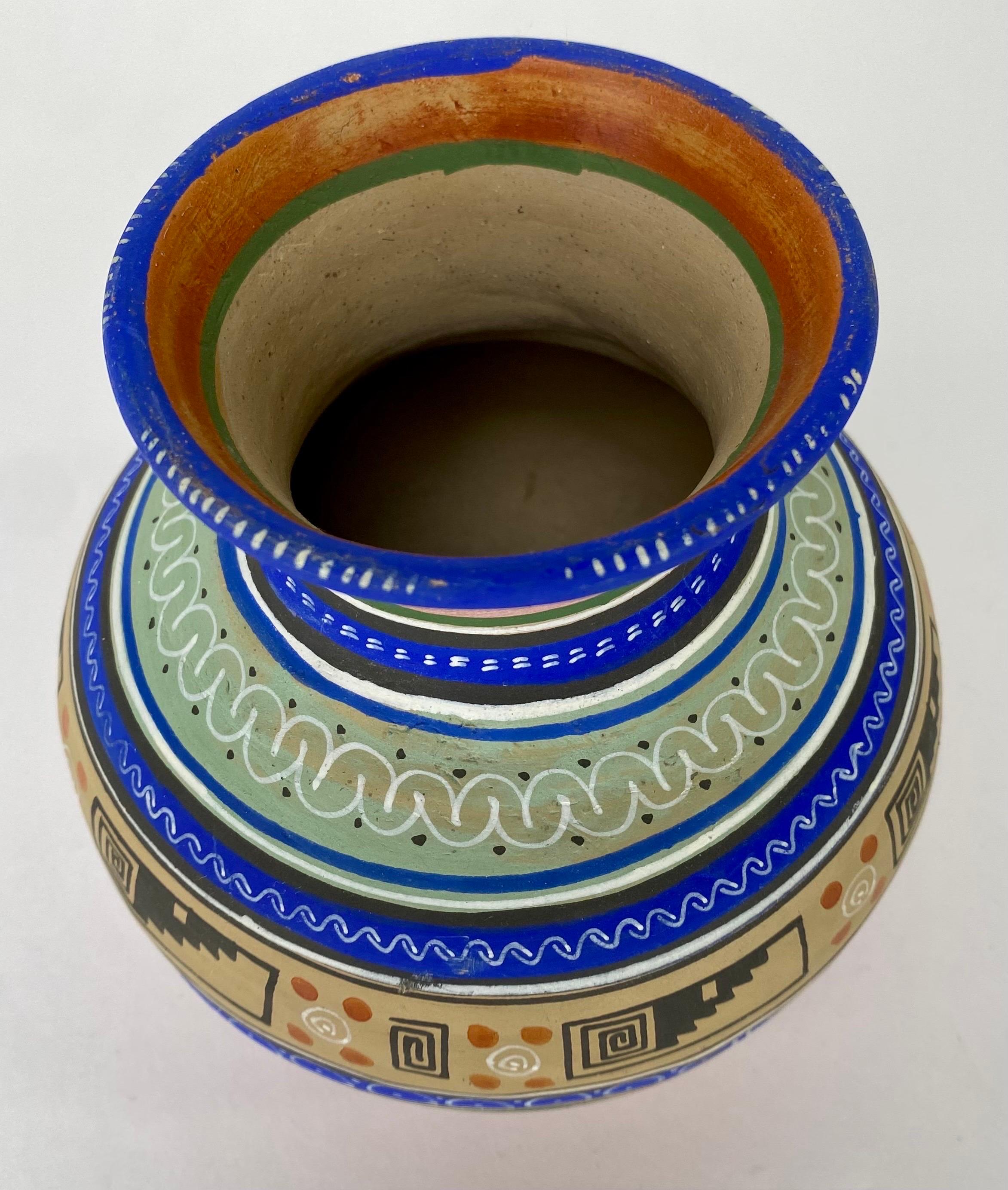 Petit vase en poterie artisanale tribale mexicaine. Ce magnifique vase présente des motifs tribaux géométriques et est peint à la main dans un magnifique bleu foncé électrique, un vert clair, un beige et un marron. Ce vase est le reflet de la riche