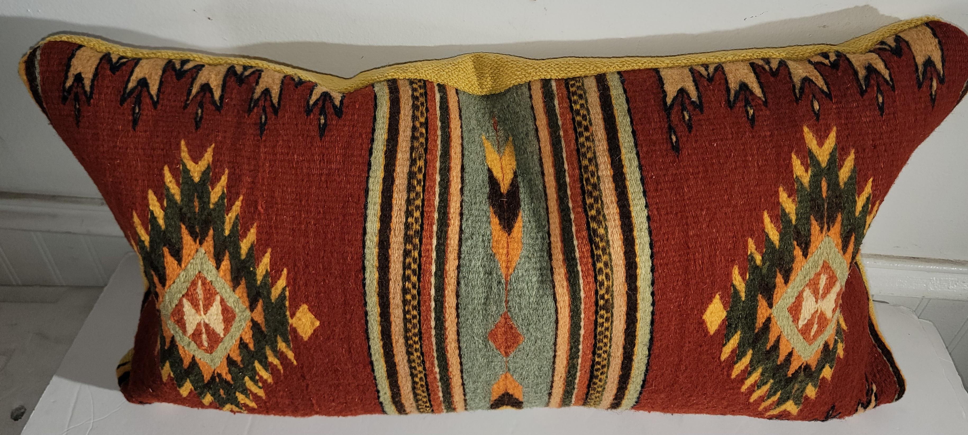 Collezione di tre cuscini di tessitura Mexican Indian con un insolito supporto di lino giallo. Gli inserti sono in piuma e piumette.