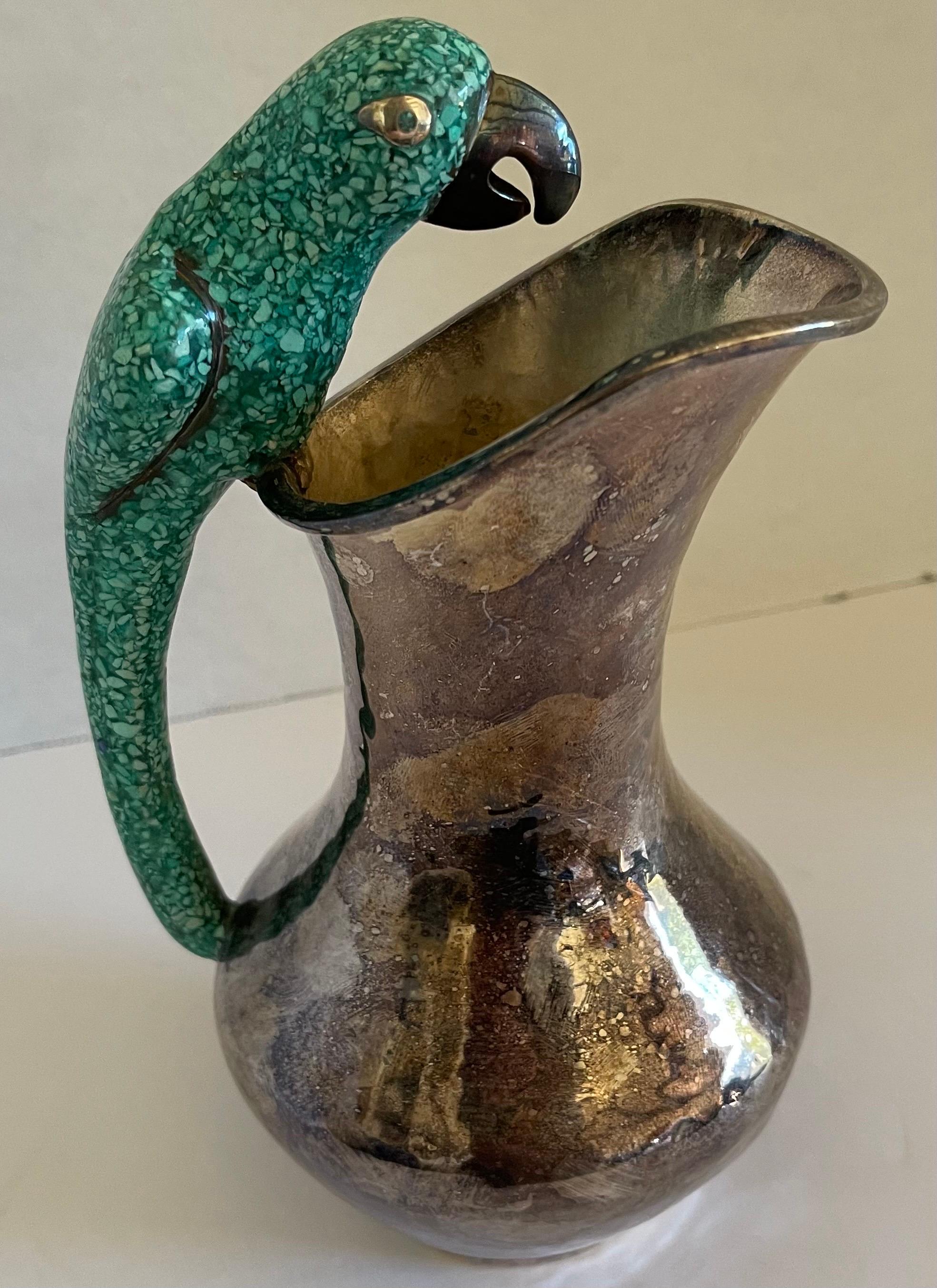 Mexican Los Castillo style parrot handle pitcher. Silver plate with lightly hammered finish and green stone parrot handle. Heavy and well made. 
No makers mark or brand stamp.
Pitcher will be polished before shipping. 