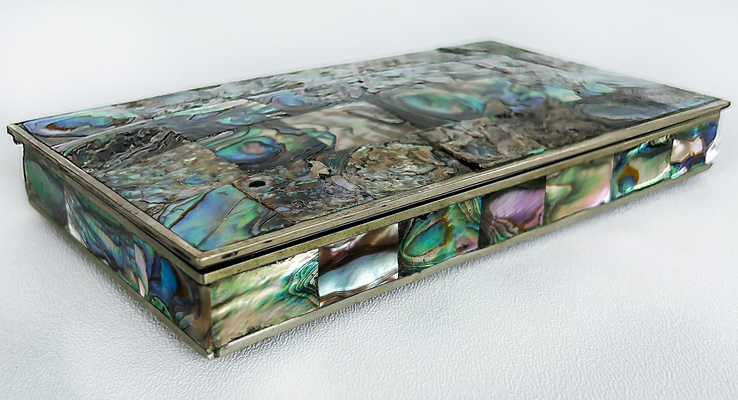 Mexican Mid-Century Modern Abalone Shell Box, Alpaca Silver

Offered for sale is a Mexican Mid-century Modern Alpaca silver decorative box that is clad in brightly colored abalone shell tiles. The lid has a slightly domed effect and the sides are