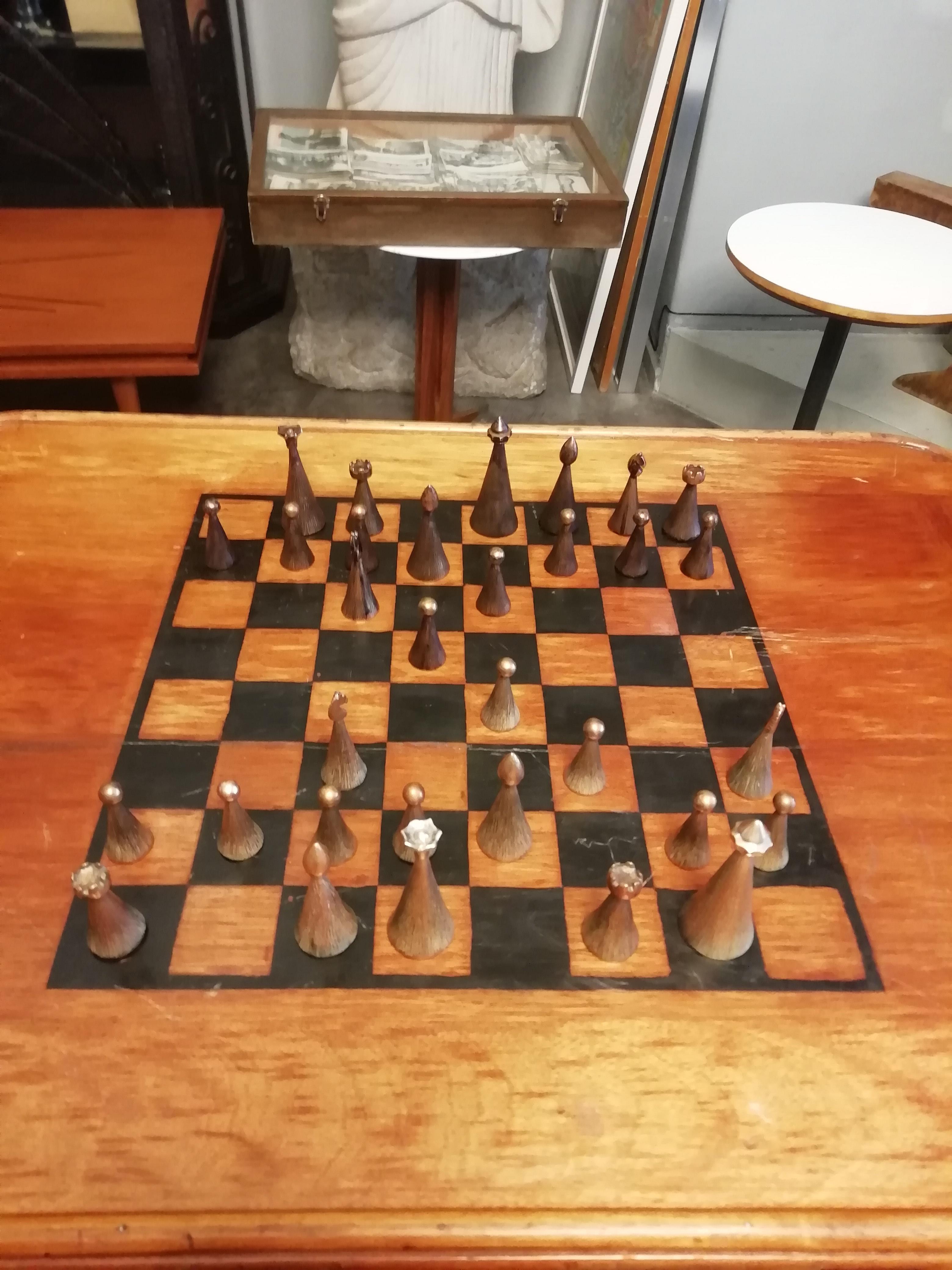 Elegant set of Mexican Mid-Century Modern bronze chess pieces. Available with a walnut harp leg game table. The pieces feature a conic design with copper heads. The chess pieces are complete to play with them.

Table's dimensions: 77 x 80 x 56 cm.