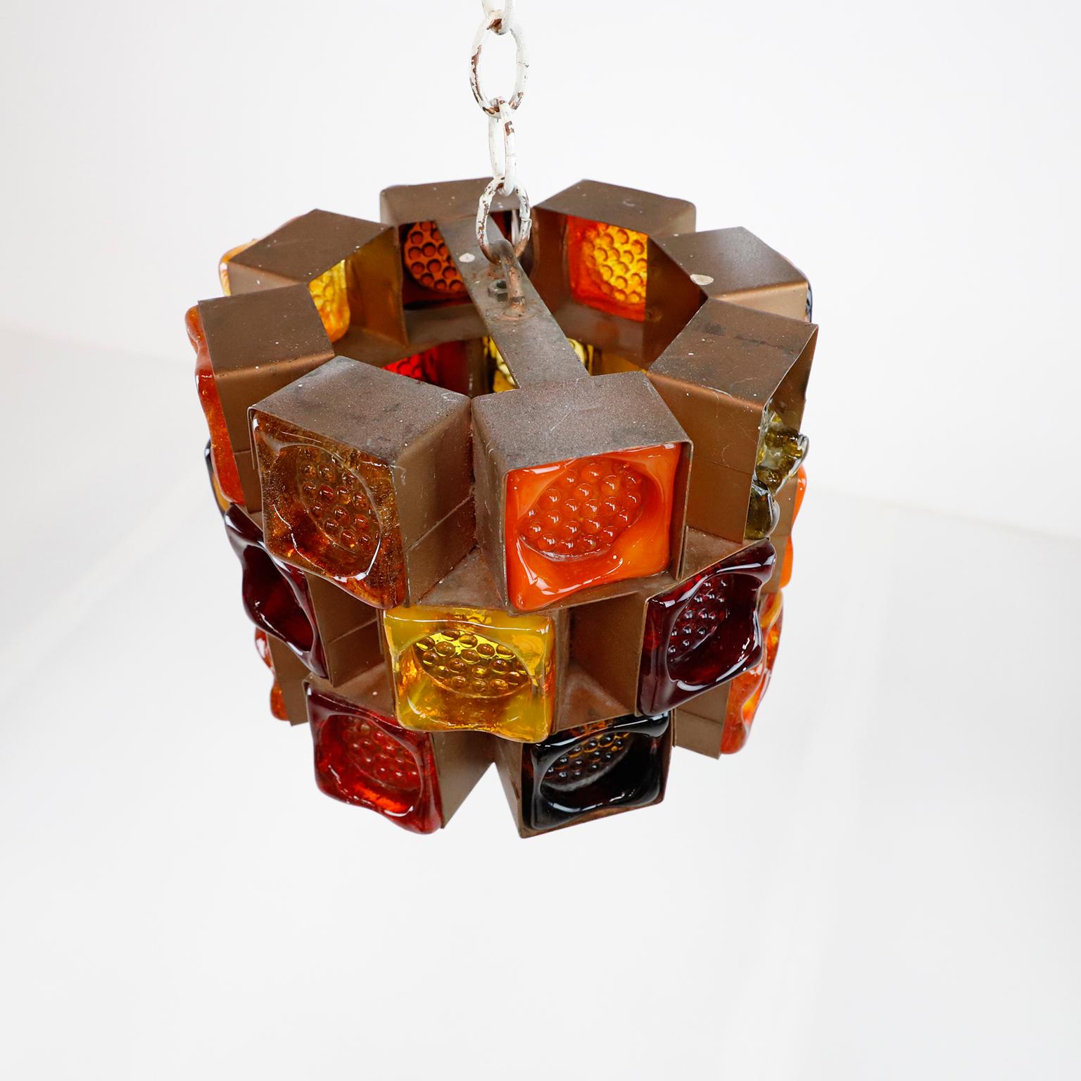 Circa 1970, we offer these original pendant light designed by Felipe Delfinger. Made of iron and multicolored blown glass. One glass is broken but it does not affect the lighting (see pic 3).