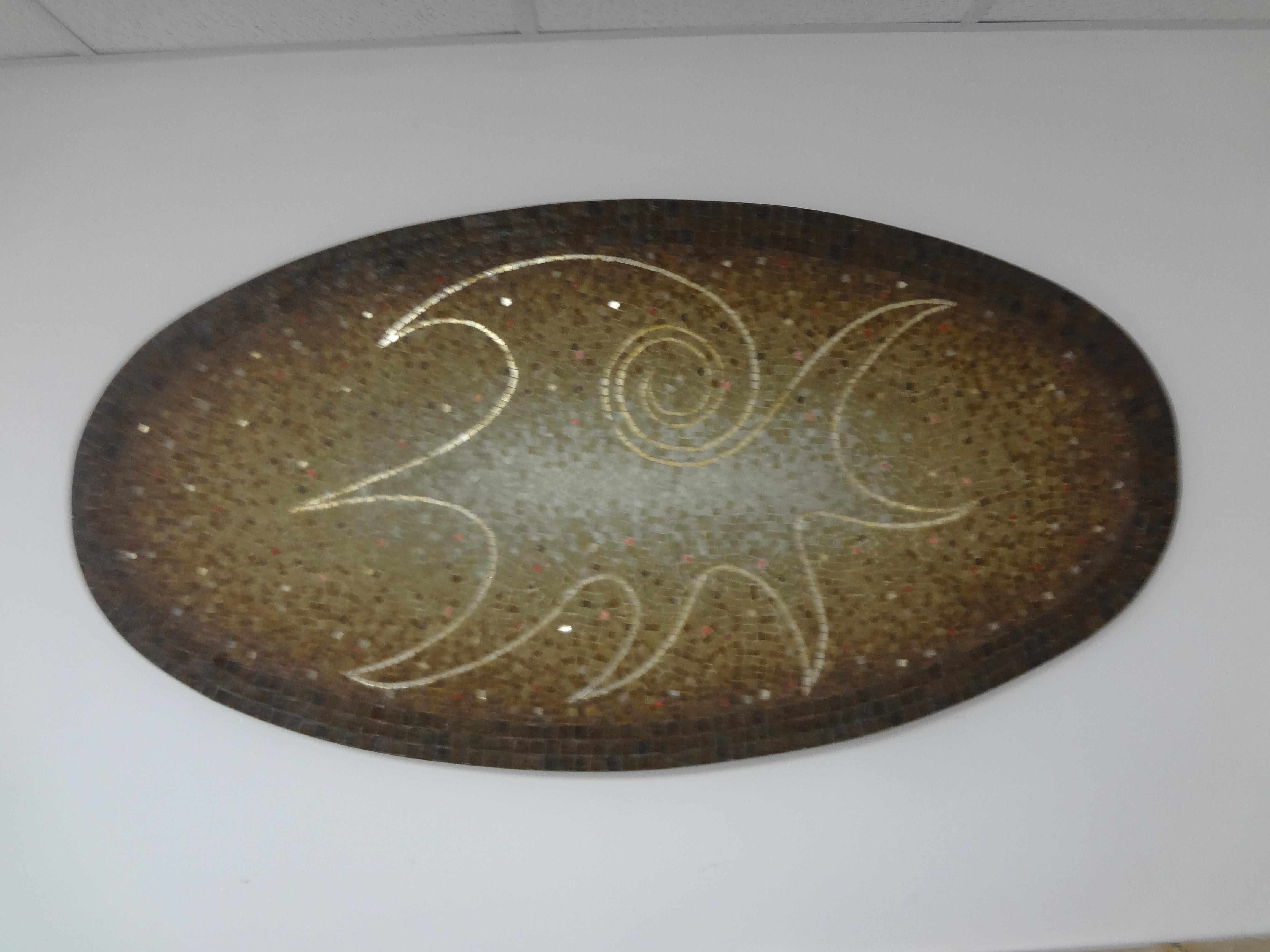 Large Mexican Modern Mosaic Tile Wall Sculpture Signed Genaro Alvarez. 
Our mid century modern wall sculpture is made up of an abstract ceramic tile design mounted on wood with a brass band border.
This stunning large Mexican modern oval mosaic wall