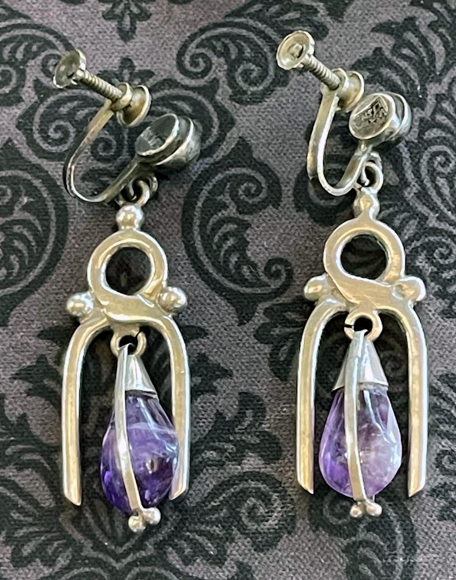 A pair of Mexican modern earrings in sterling silver with teardrop amethyst circa 1950-60s. The earrings are screwed on as shown and marked with his period logo on one and silver on the other. 
Available also are two brooches with similar design.