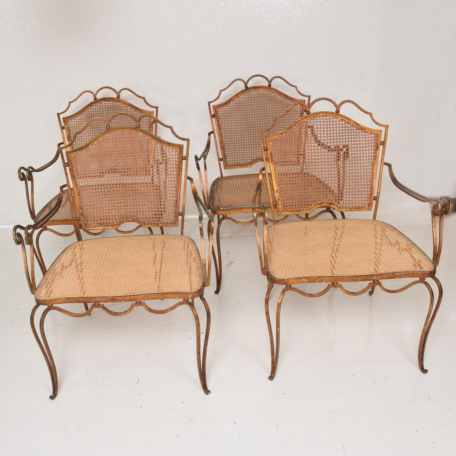 For your consideration, a Mexican modernist armchairs by Arturo Pani armchair, four chairs are available. 

Mexico City, circa 1950s.
Forged iron with gold leaf finish and wicker seat and backrest.
Dimensions: 33 3/4