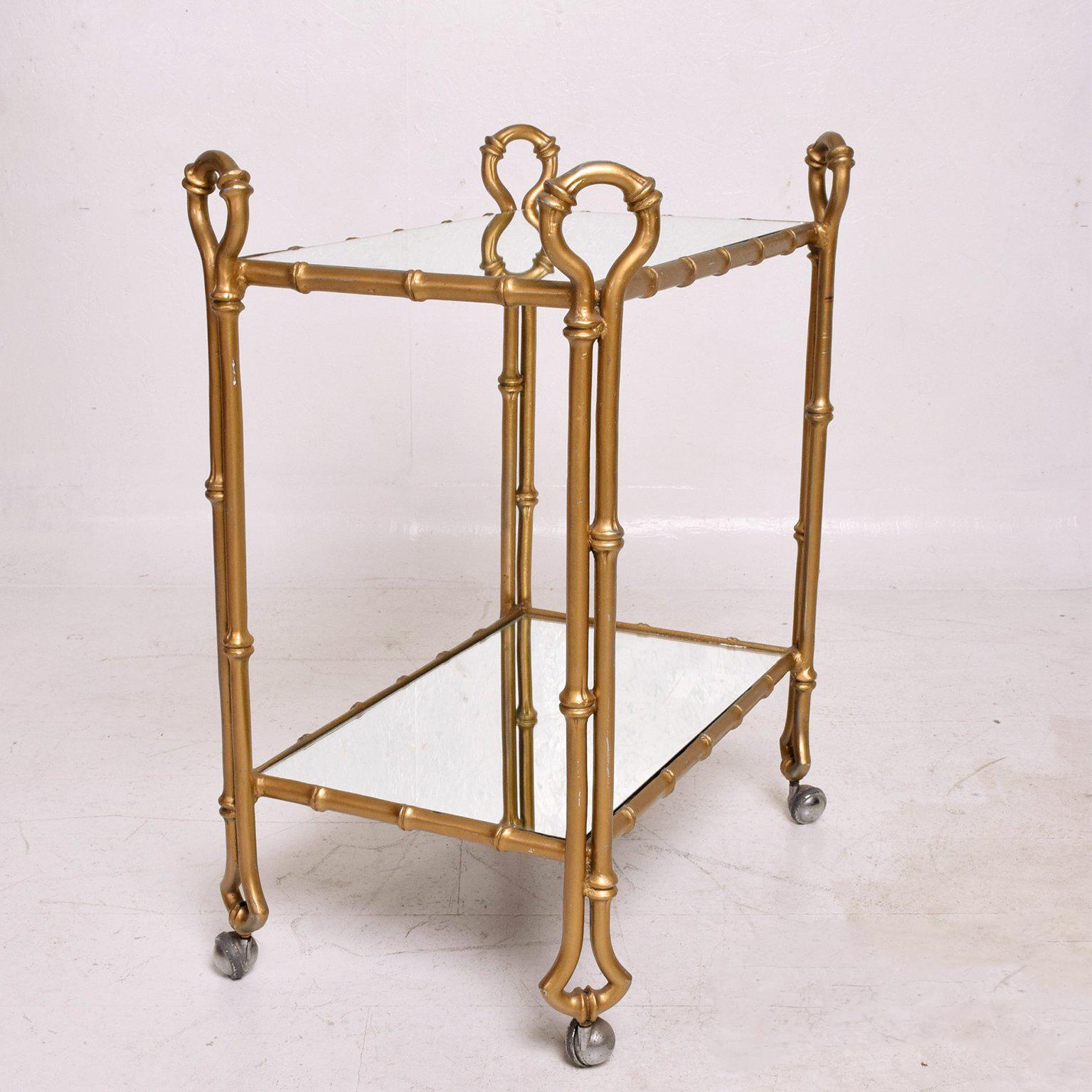 For your consideration a vintage service cart in faux bamboo (cast aluminum) in gold finish with new mirror shelves.

Finish has vintage wear and scuffs. It could be restored to meet customer specifications. 

Mexico circa 1950s. Unmarked. No