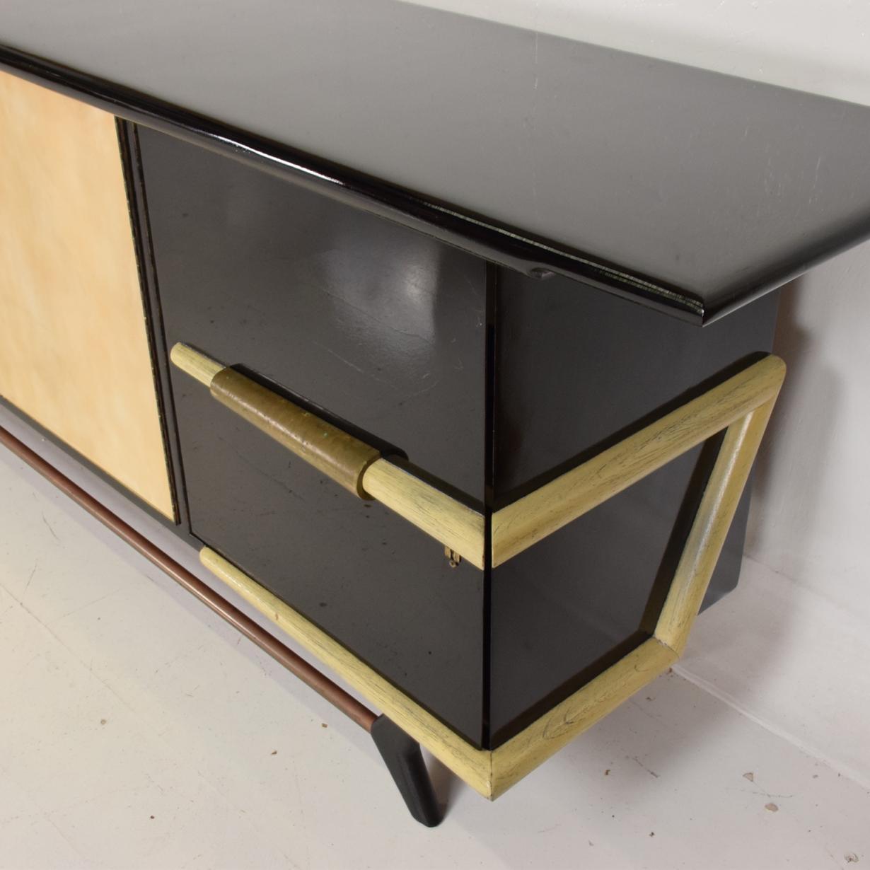 For your consideration a beautiful credenza made in mahogany with a custom finish (black glossy lacquer).

Attributed to Eugenio Escudero. Center doors are covered with goatskin. Beautiful brass accents with original patina. 

Parchment doors with