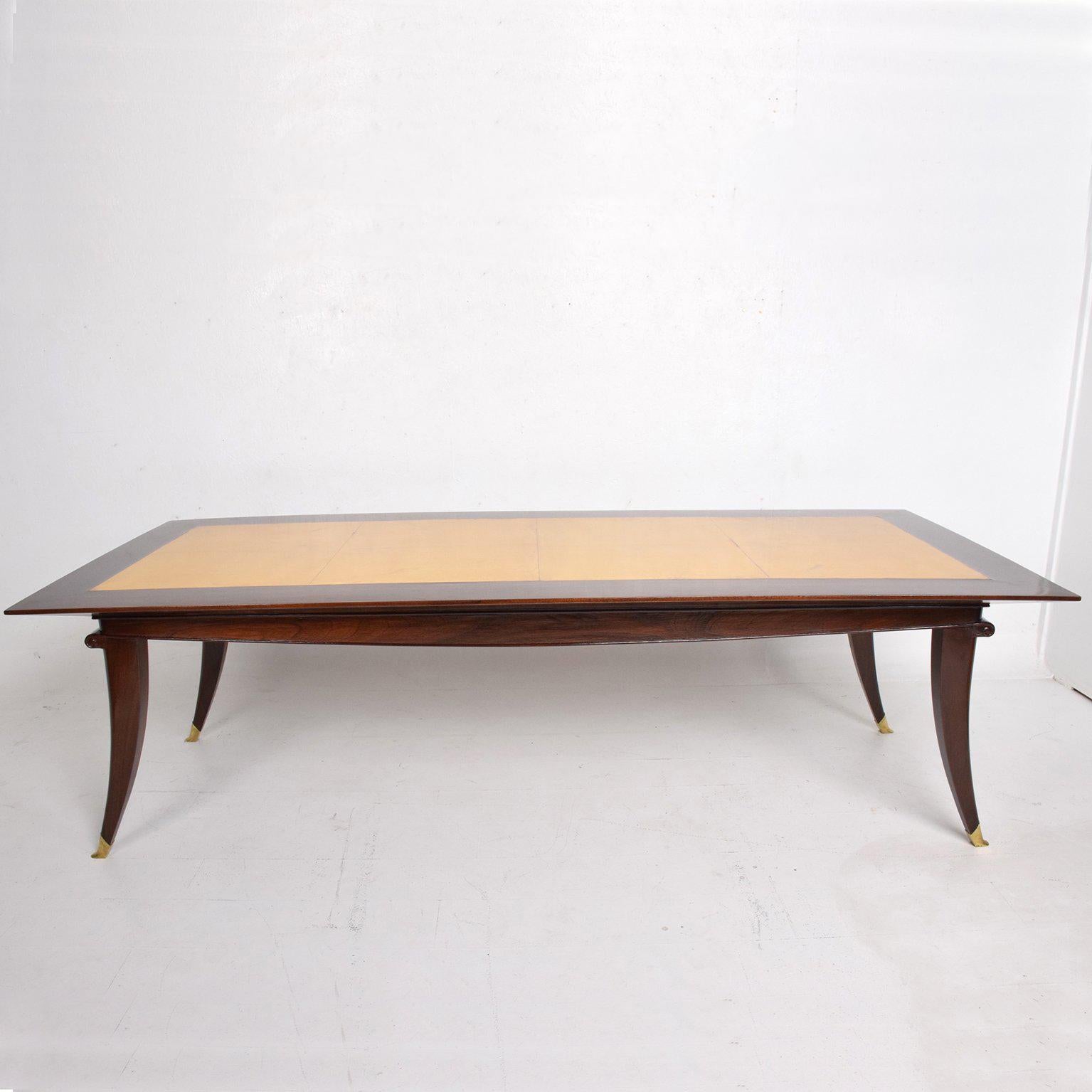 For your consideration a beautiful dining table in solid Mahogany wood with goatskin top and sculptural solid brass sabots.

Sculptural shape with tapered legs.
It can fit eight chairs.

Unmarked, no label or signature from the maker present.
