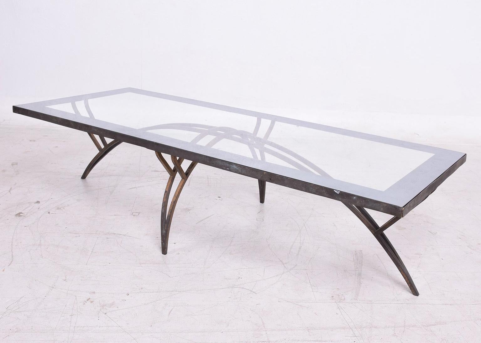 For your consideration a rectangular coffee table with elliptical sculptural legs. 
The table ins constructed with bronze legs. The rectangular frame is made of steel with a bronze face plate and a glass top with silver band. 

The bronze has the