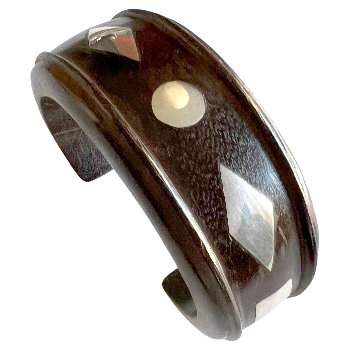 Rosewood and sterling silver cuff bracelet in the style of William Spratling. Cuff measures 1 3/8