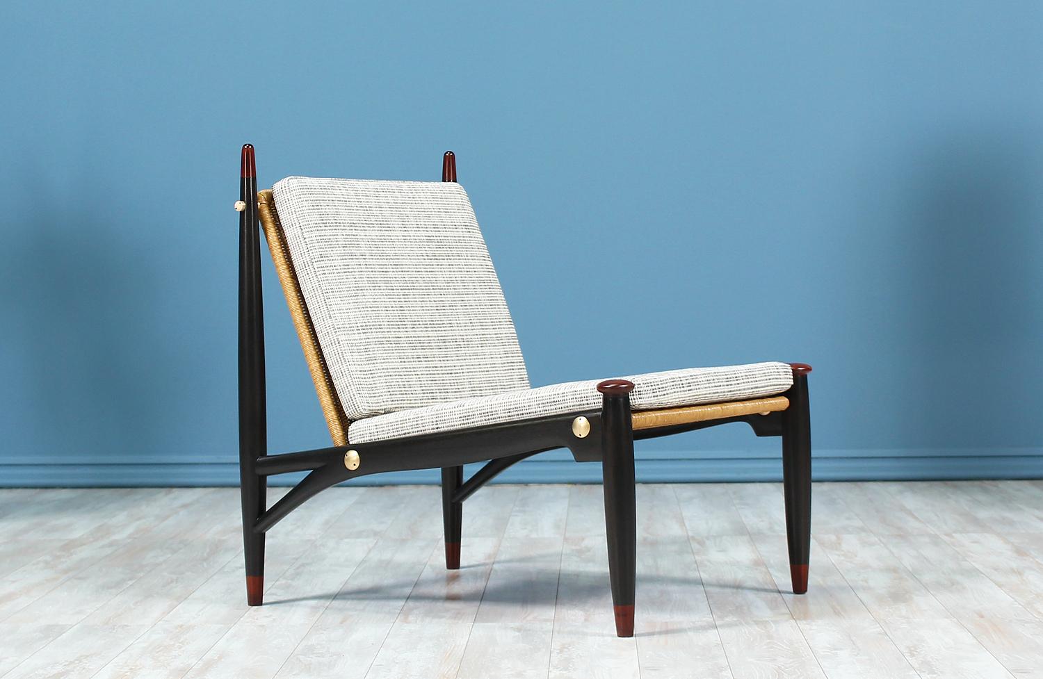 Stunning lounge chair designed by Frank Kyle for Frank Kyle Studio in Mexico circa 1950’s. This rare design features a newly re-caned wicker seat supported by polished brass hardware. The ebonized mahogany wood frame features subtle hints of