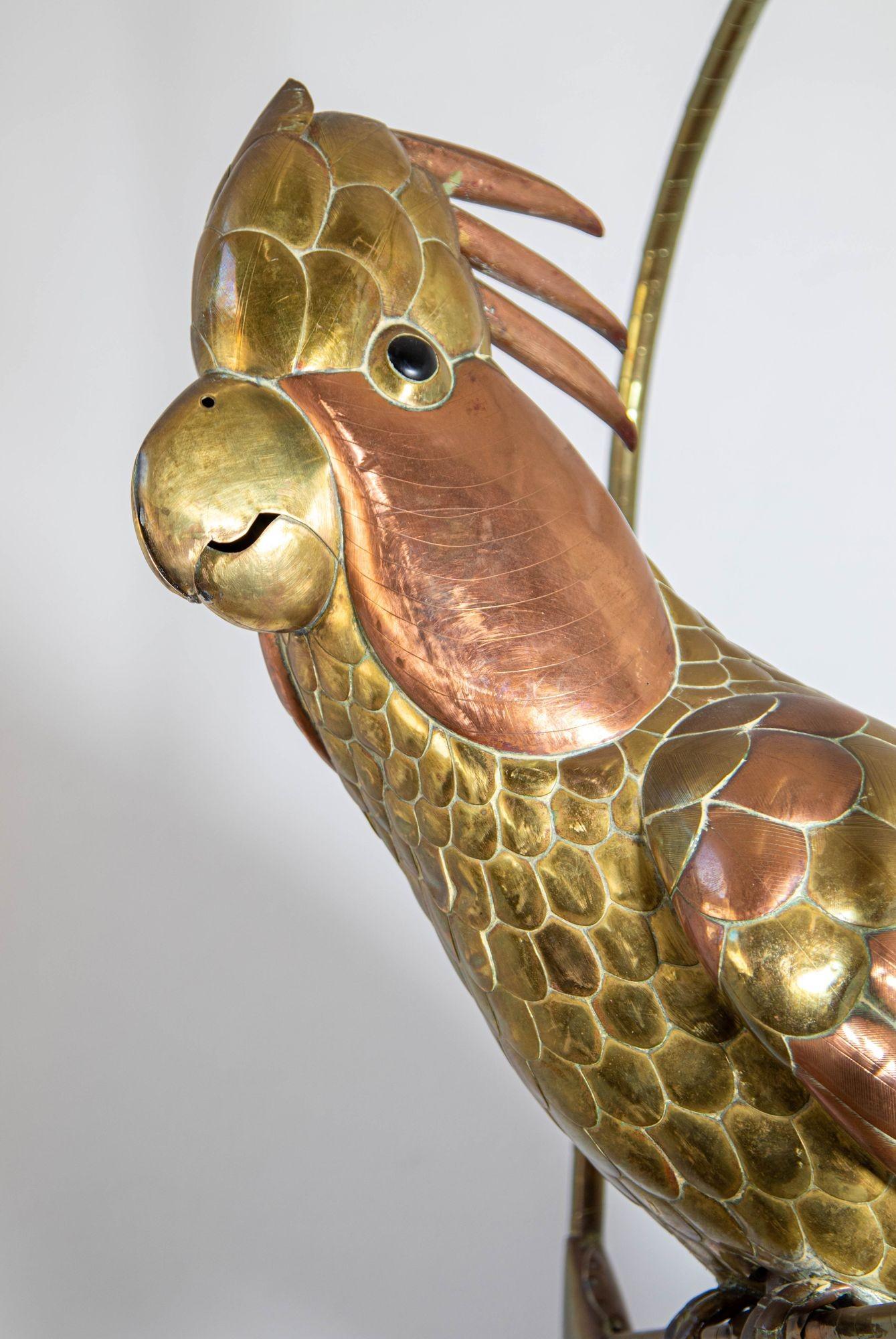 Mexican Sergio Bustamante Style Copper and Brass Cockatoo or Parrot on a Swing, signed by unknown artist.
A Brass and Copper Cockatoo with Head Feathers in the style of Sergio Bustamante 1960s.Mexican Lifesize Mid-century folk art brass and copper