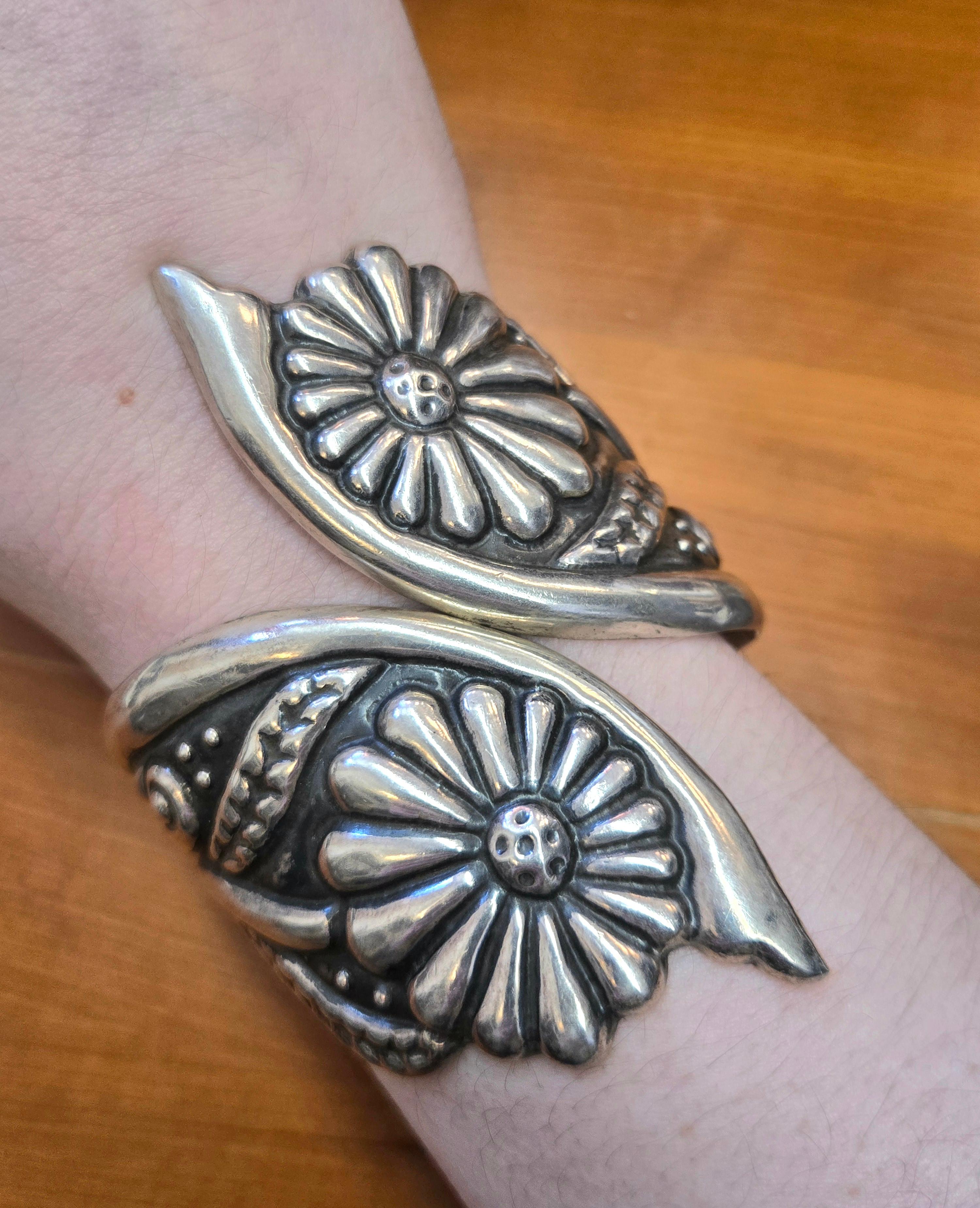This charming Mexican silver clamper bracelet features two sunflowers sitting atop one another. Measures 7