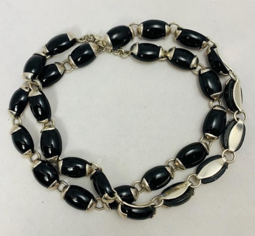 Unique and stunning vintage Mexican silver and onyx chain necklace. This generously long necklace features 27 individually silver encased onyx stones and a box style clasp. Modern design sensibilities with a timeless look. Very good condition,