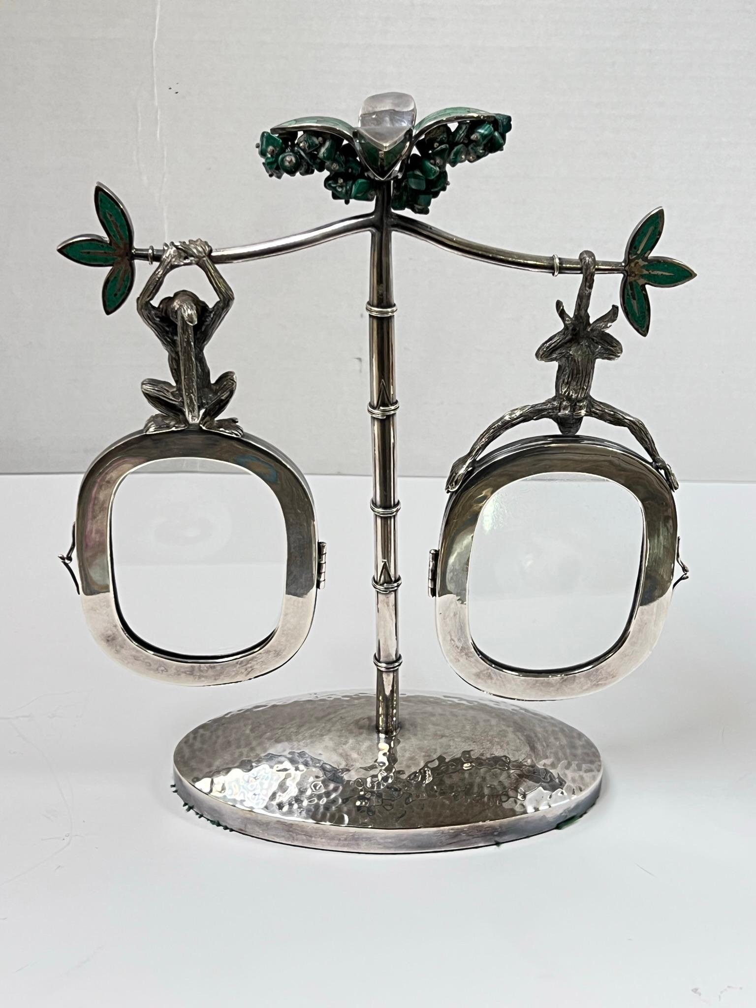 Charming vintage silverplate picture from by Emilia Castillo of Taxco, Mexico, with bamboo standard on hand-hammered oval base, malachite-stone inlaid flowers at the top and two oval picture frames suspended by hanging monkeys from two branches.  