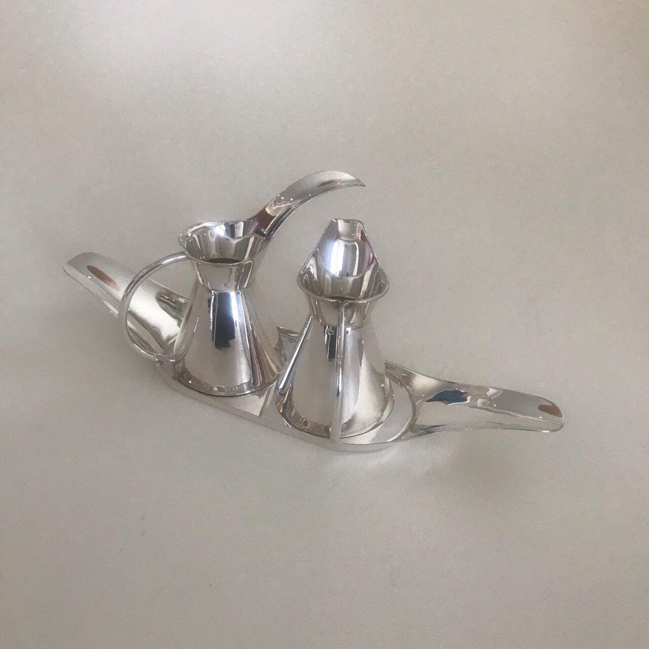 Mexican sterling silver condiment set by Sanborn

Two loop handled decanters resting on a long narrow tray with upraised handles to each end. 

Charming midcentury design. Multi purpose.

Made in Mexico.