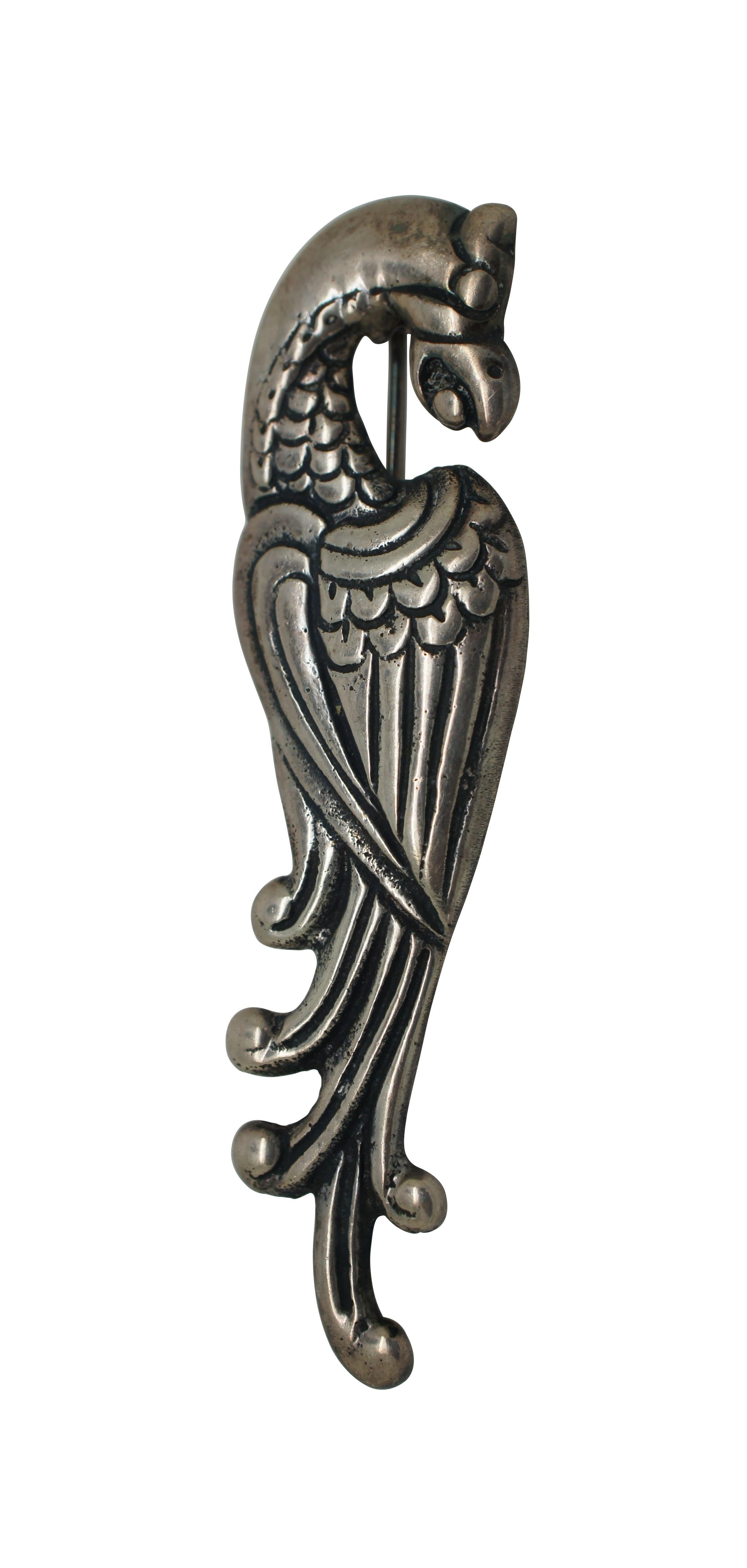 Vintage Mexican sterling silver pin / brooch in the shape of a heraldic Quetzal bird / Eagle / Dragon or Phoenix with a small ball in its beak.  Marked Sterling on verso. Straight pin back.

Dimensions:
0.875” x 0.125” x 3.125” (Width x Depth x