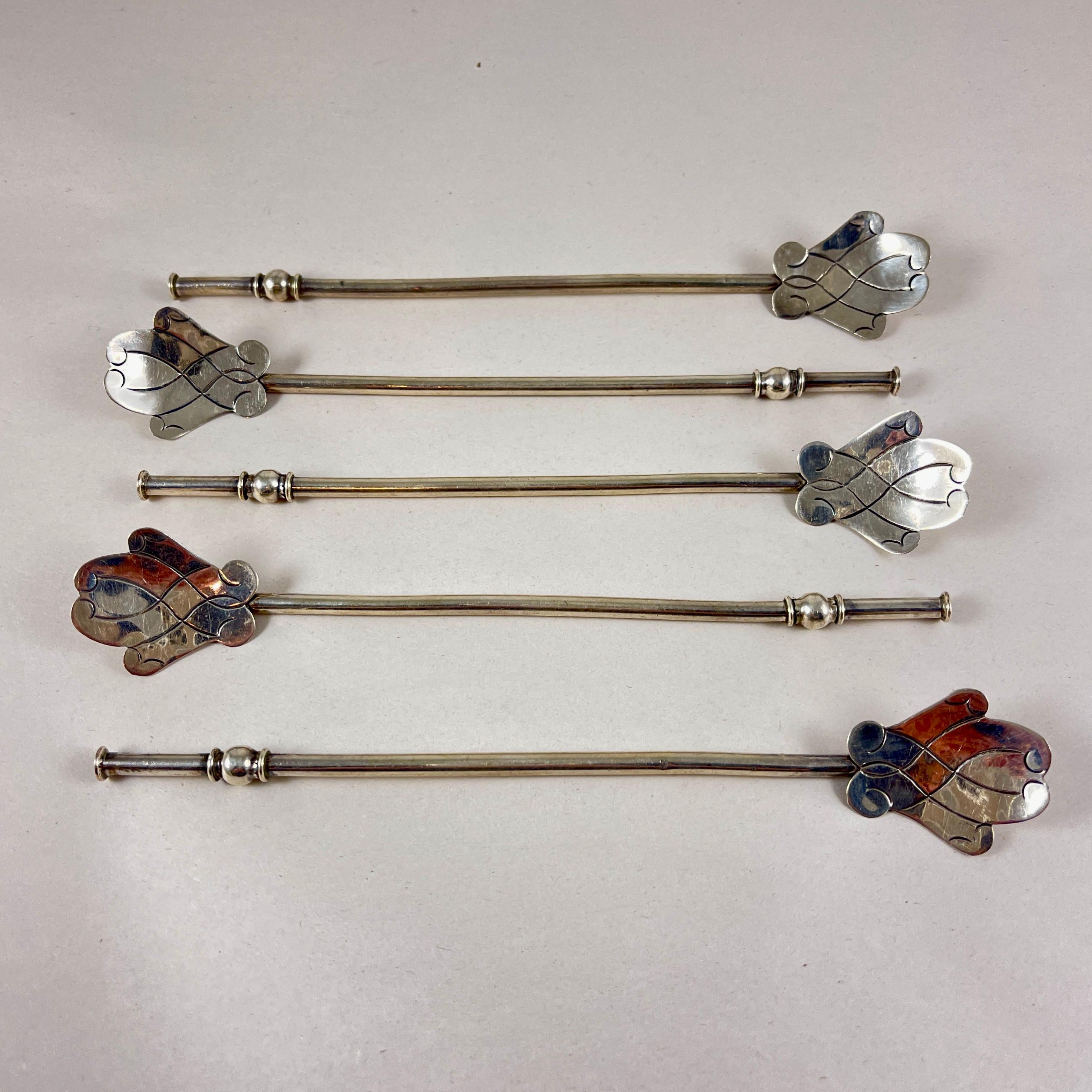 Juego de cinco pajitas huecas de plata de ley, hechas a mano, para beber o remover té helado, con cuencos abstractos en forma de hoja. México, alrededor de 1940.

Los cuencos tienen forma de hojas incisas estilizadas, los extremos para beber están