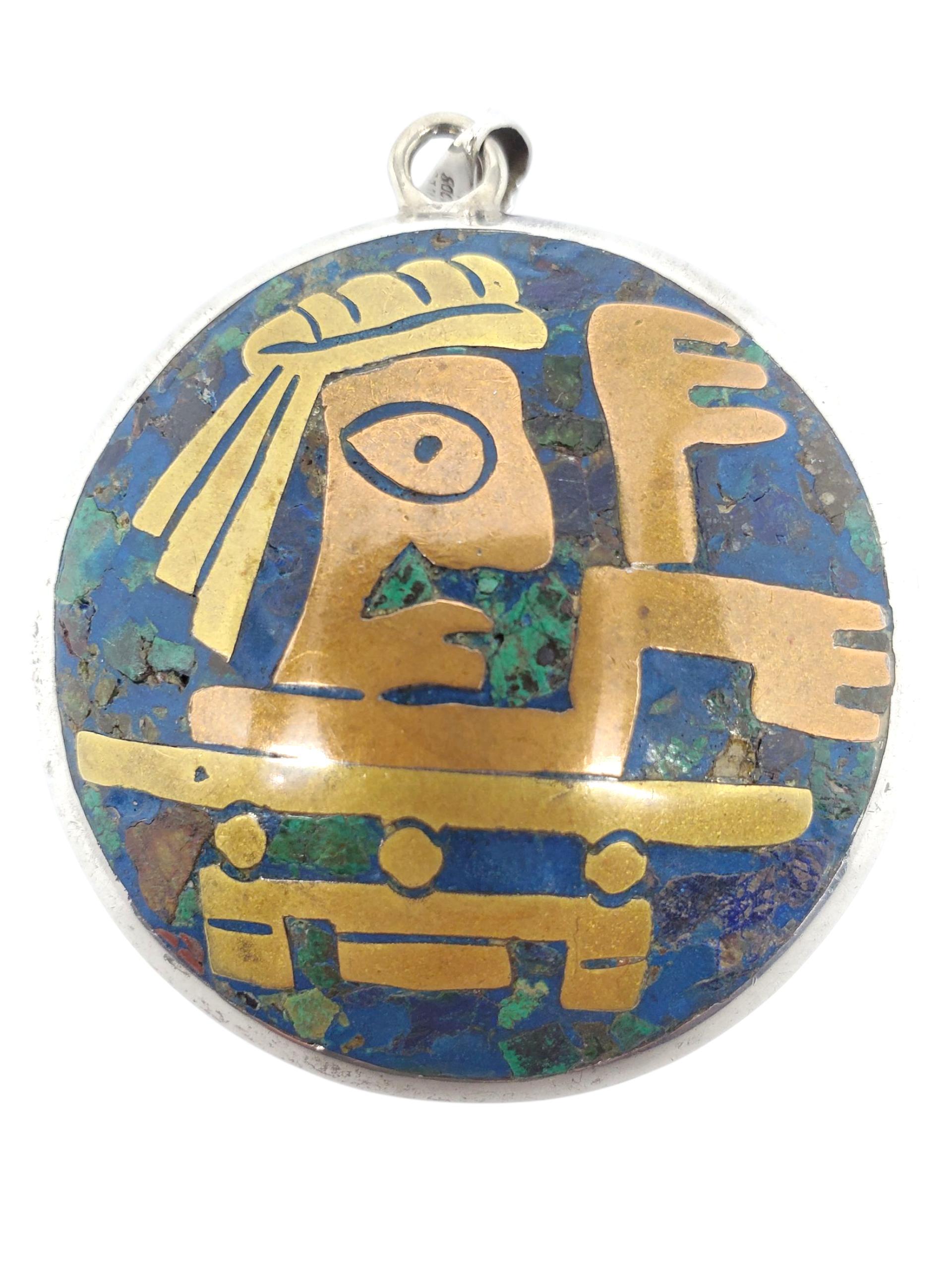 Ciondolo circolare azteco grande in argento massiccio - A. Silver

Questo splendido ciondolo in argento sterling di Mec Sajos presenta un intricato intarsio di ottone su un composito di azzurrite/malachite in un disegno azteco a doppia