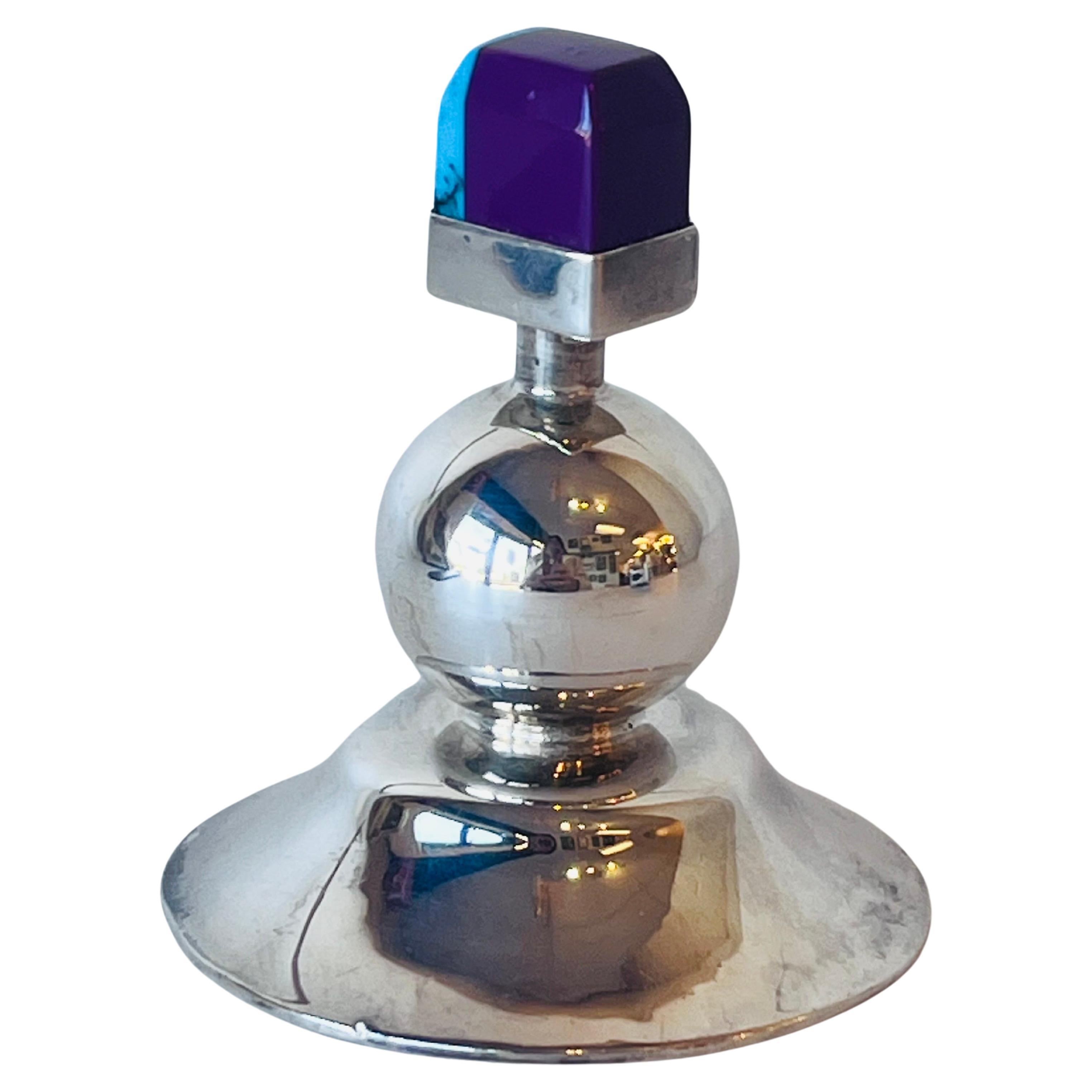 A vintage sterling silver Mexican post modern style perfume bottle with a multi colored threaded stopper. The sloped and slightly undulating conical form is topped by a spherical design and then finished by the multi colored stopper. I am unsure of