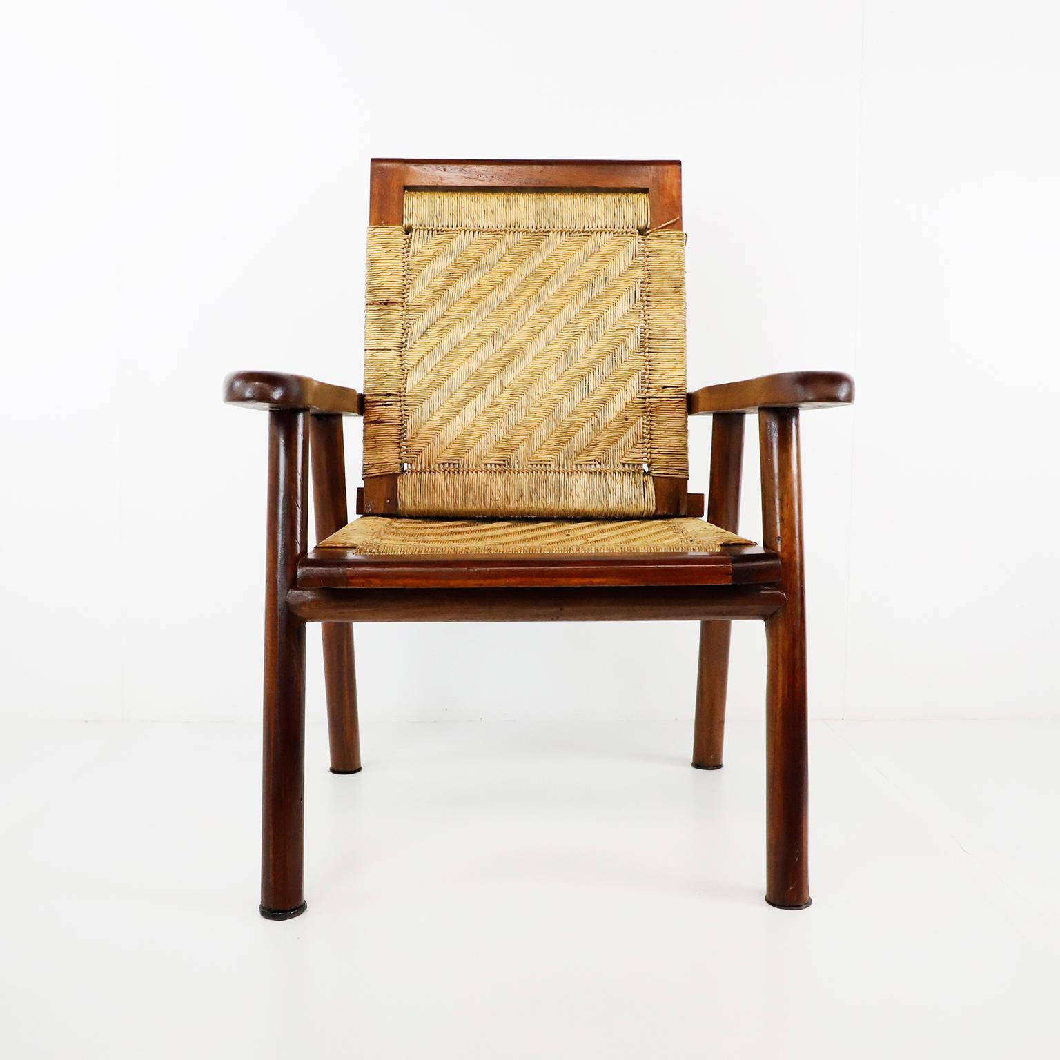 Circa 1950. We offer this Mexican woven lounge chair in the style of Clara Porset made in solid mahogany. This armchair provides a surprising amount of comfort with its beautifully woven seat. The chair is in great vintage condition and recently