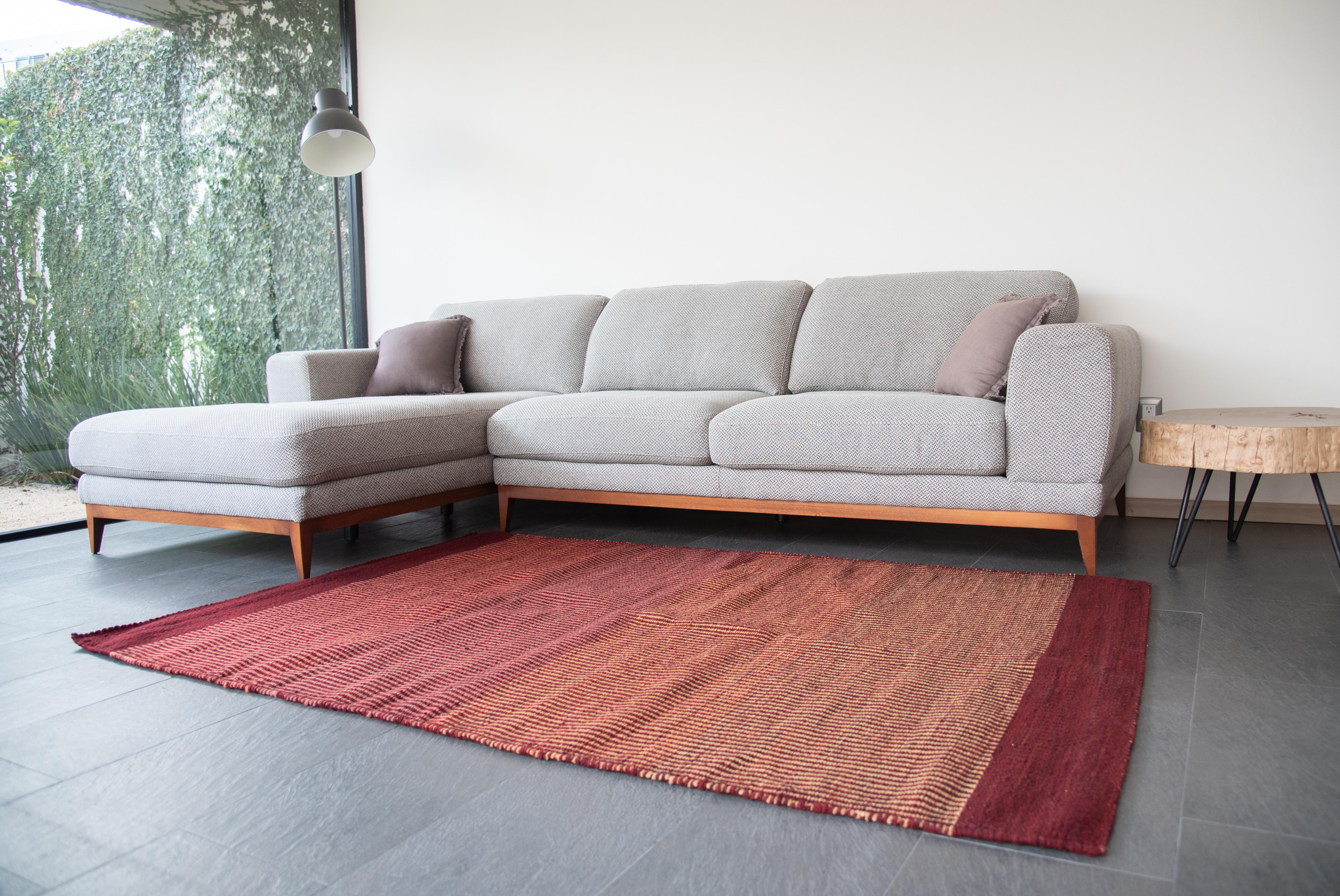 This abstract rug is made by master weaver Roman Gutierrez in Oaxaca, Mexico. 
Red wine, fuchsia and colors are light mustard tonalities are portrayed in this modern Zapotec rug. The contemporary Mexican design is made of cozy wool which is