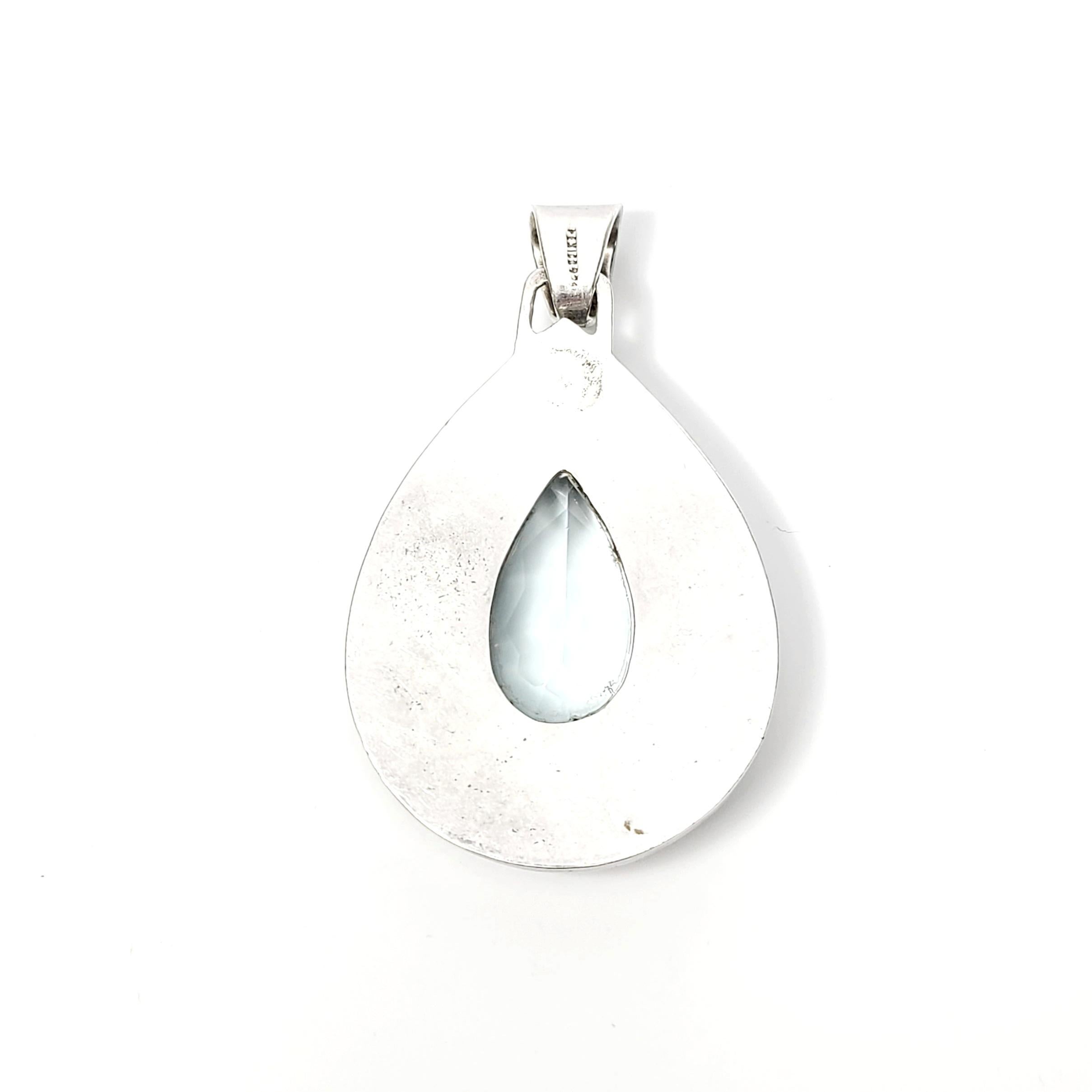 Mexican sterling silver and aquamarine colored glass teardrop pendant.

This handcrafted artisan piece is large and substantial featuring a large faceted glass teardrop stone in a light aquamarine color bezel set in a teardrop shape frame with a