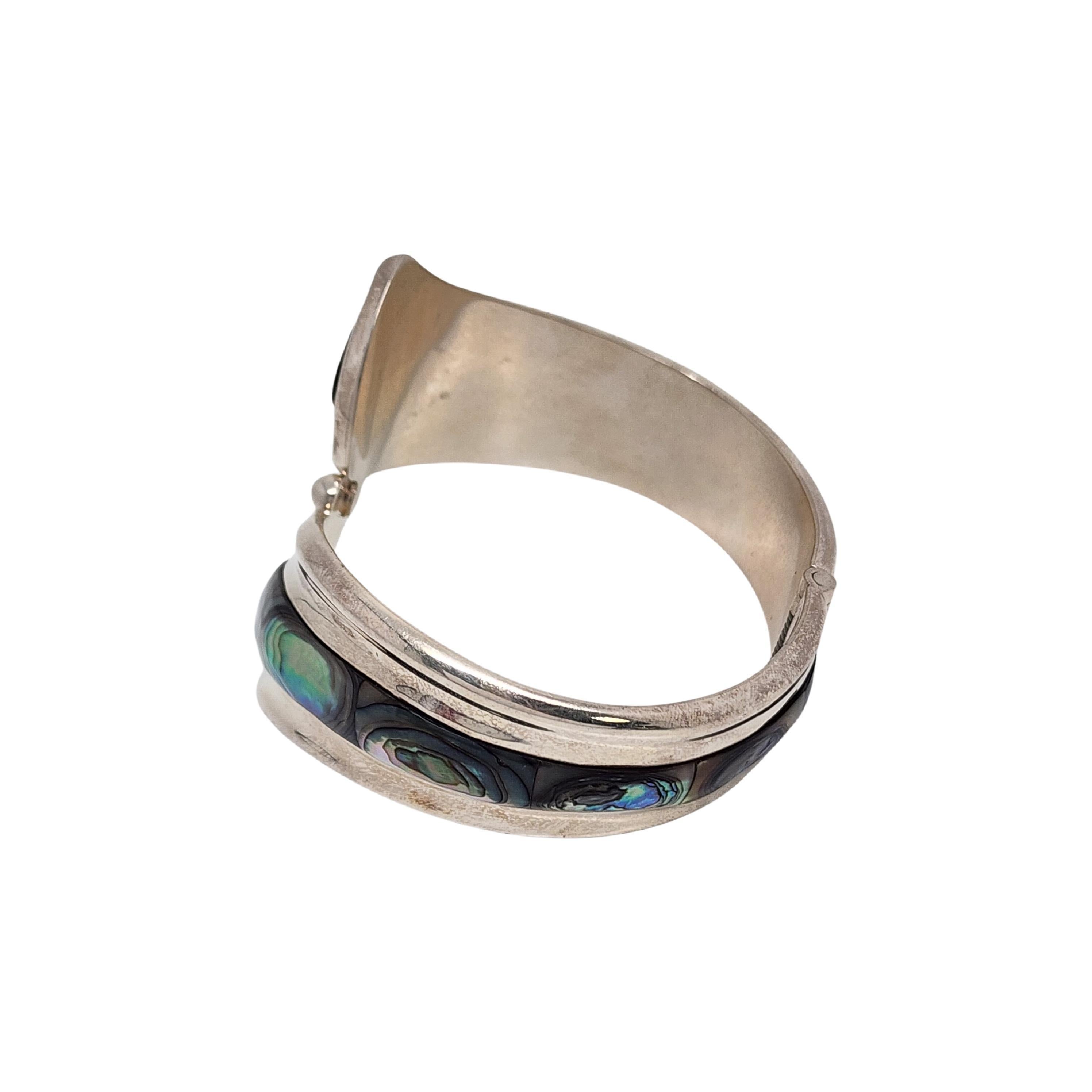 Sterling silver and abalone shell hinged bracelet from Mexico.

A large and significant bracelet featuring beautiful abalone shell in a hinged bypass design.

Weighs approx 62.0g, 39.9dwt

Measures approx 7 1/4