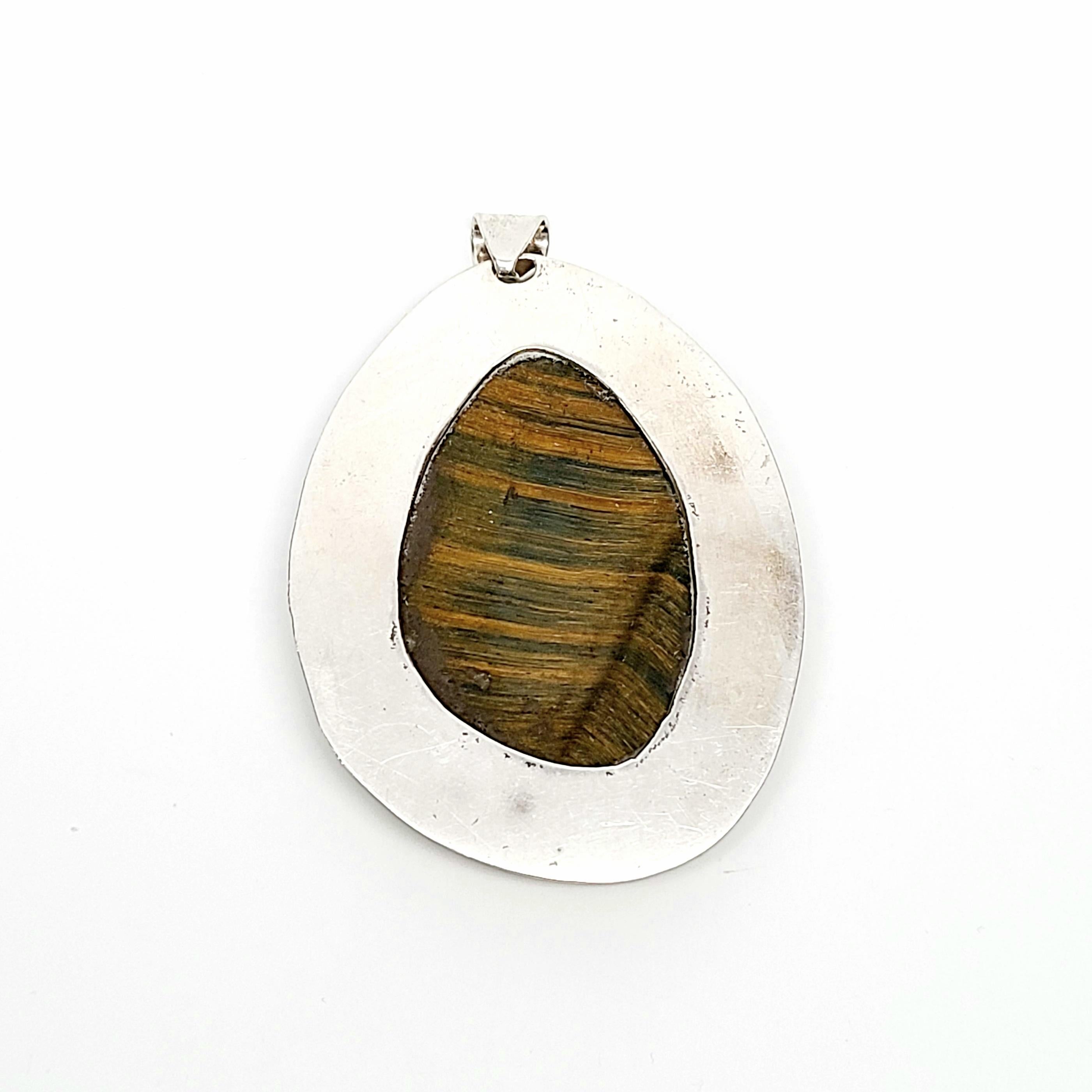 Sterling silver and tiger's eye large pendant.

A large, beautifully banded tiger's eye stone is bezel set in an etched frame.

Measures approx 2 7/8