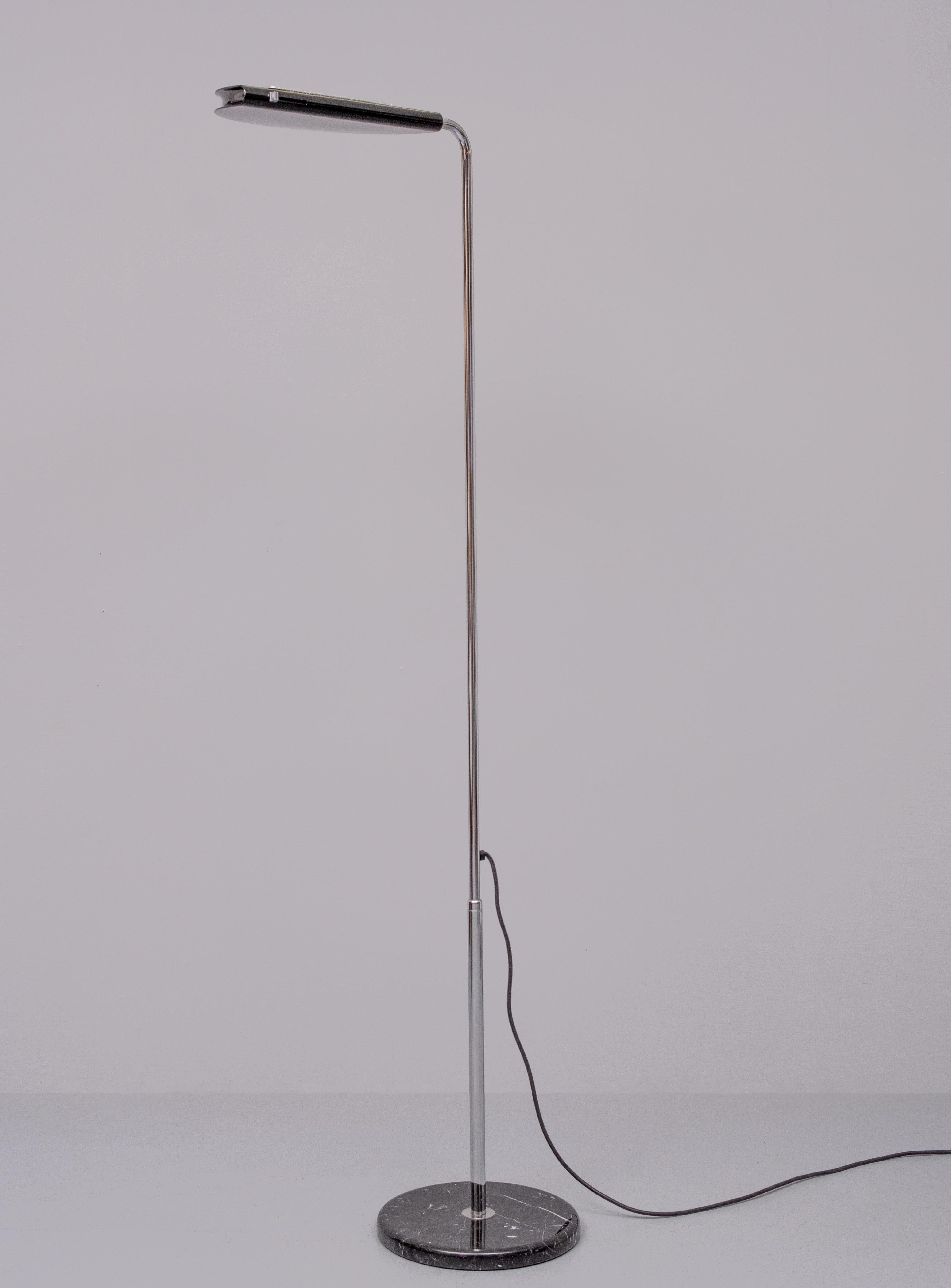 This beathiful Italian floor lamp, model Mezzaluna, was designed by Bruno Gecchelin in 1974 and produced by Skipper. The floor lamp has a tubular chrome-plated steel structure, a Black marble base and an adjustable black enameled head. Dimmable