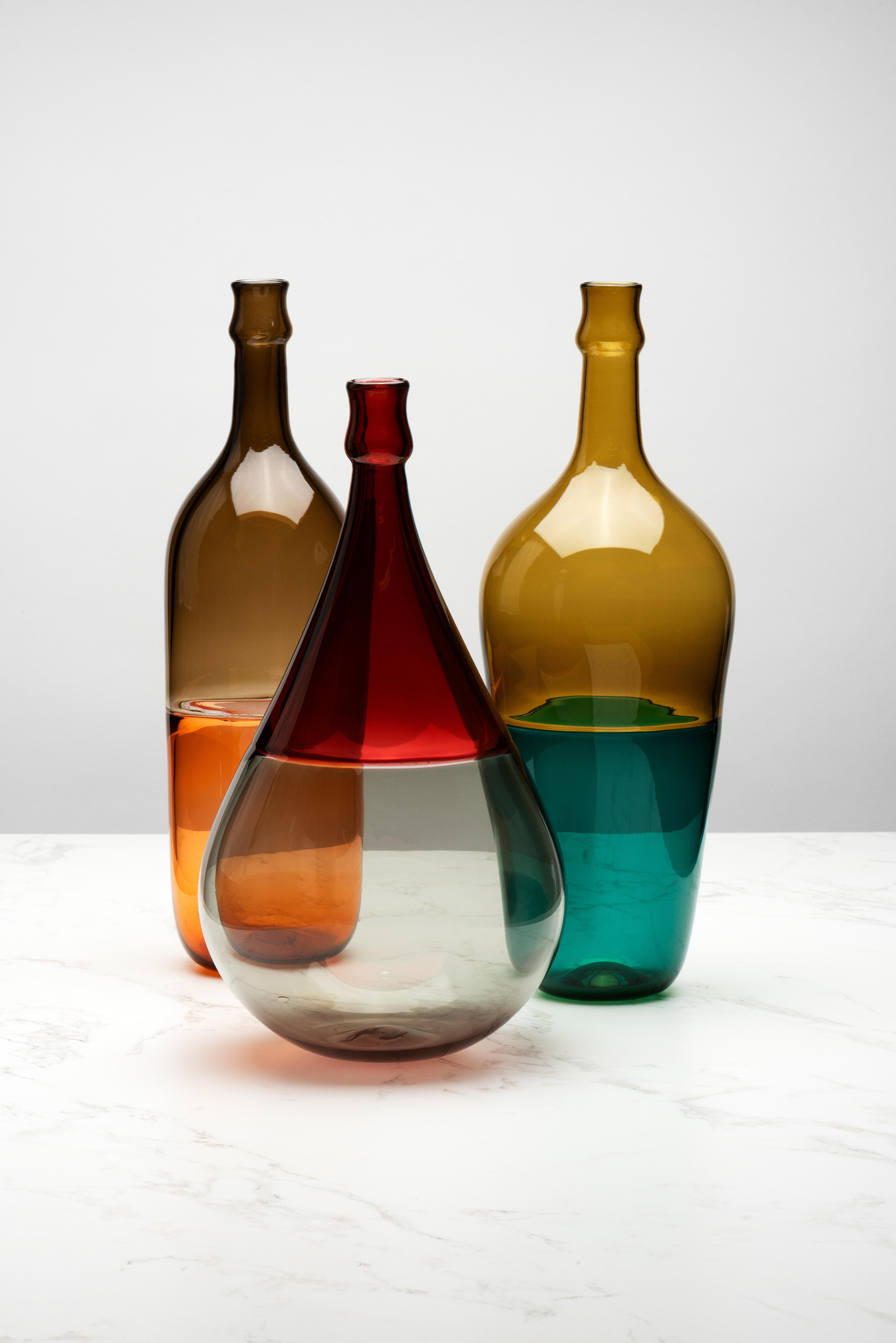 These bottles were inspired by the traditional Italian chianti fiasco bottles with their woven straw bottom half. In the spirit of sharing a drink with a table of people, these bottles are called Mezzo Vuoto which in Italian means “half empty”. The