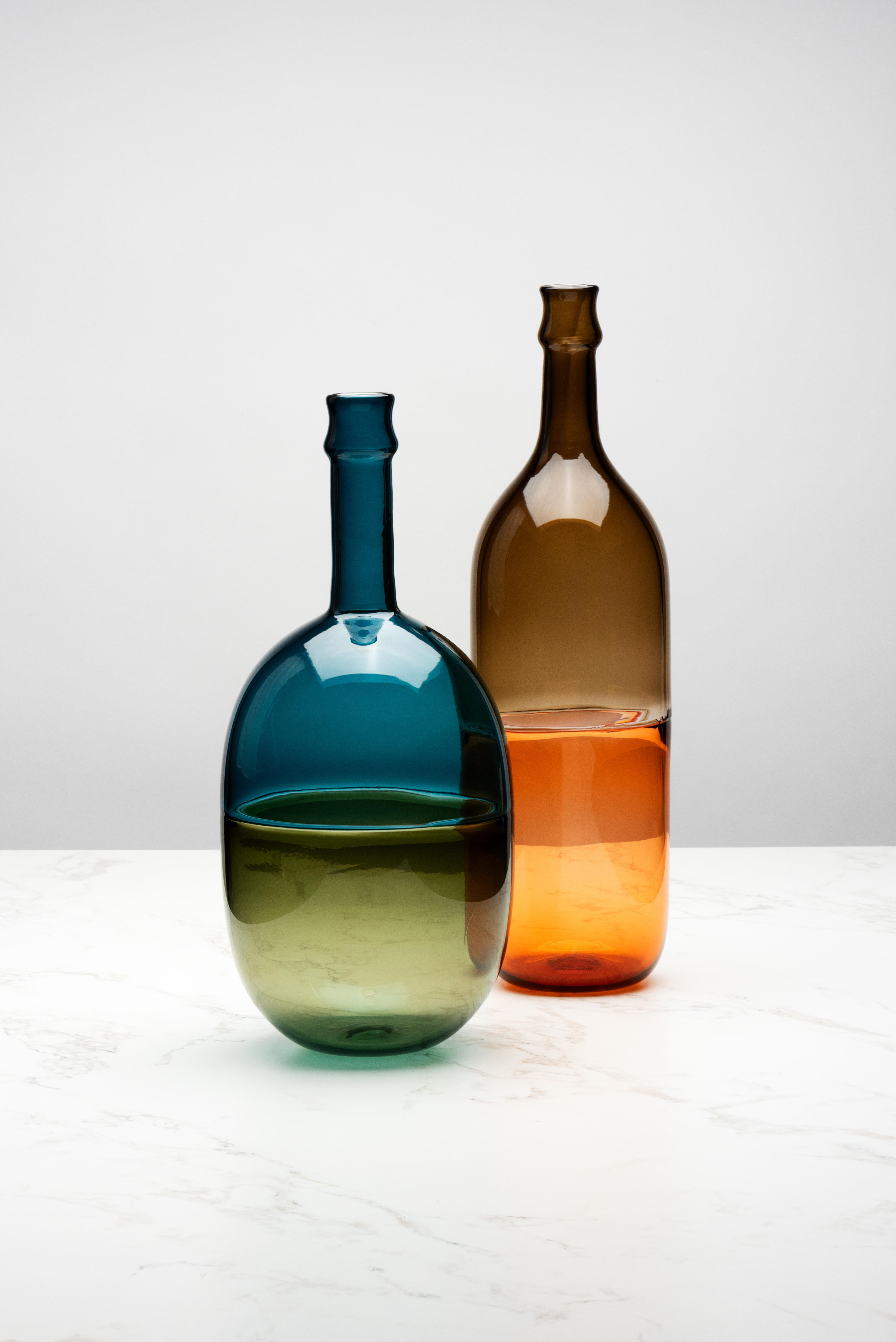Queste bottiglie sono state ispirate dalle tradizionali bottiglie di chianti fiasco italiane con la loro metà inferiore in paglia intrecciata. Nello spirito di condividere un drink con un tavolo di persone, queste bottiglie si chiamano MEZZO VUOTO,
