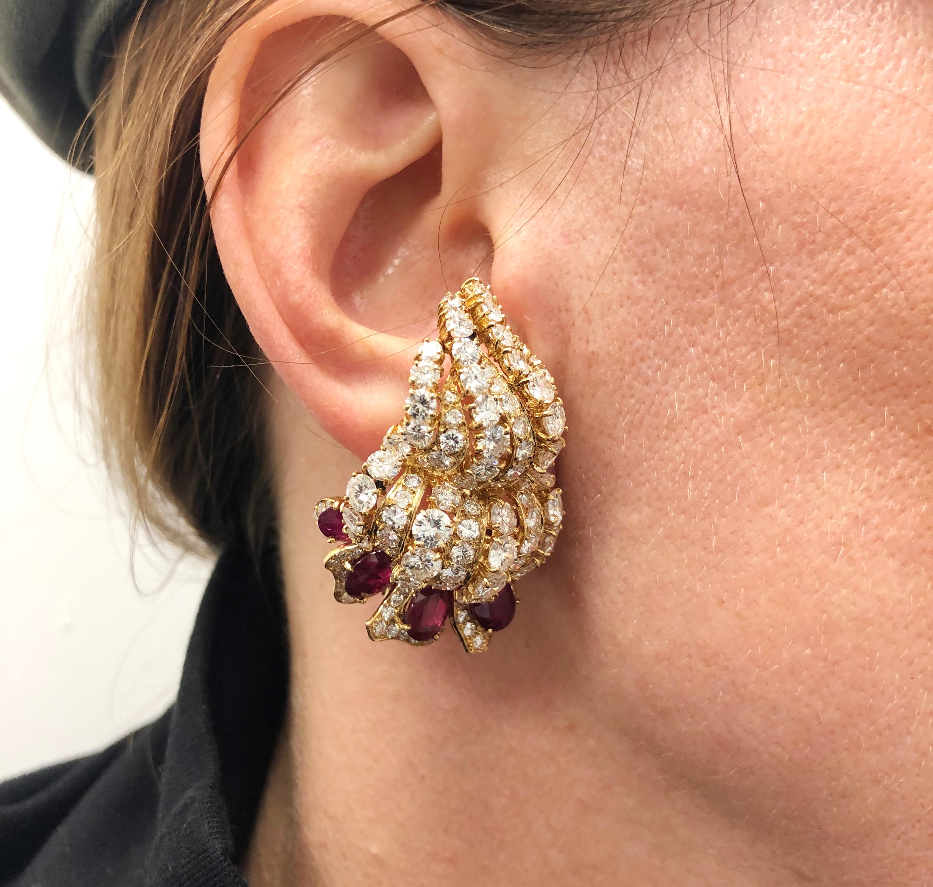 Designed by the renowned jewelry house M. Gerard, comprising a remarkable pair of earrings that date back to the 1960s,  crafted in 18k yellow gold, exquisitely set with oval and circular-cut rubies and brilliant round cut diamonds, with detachable
