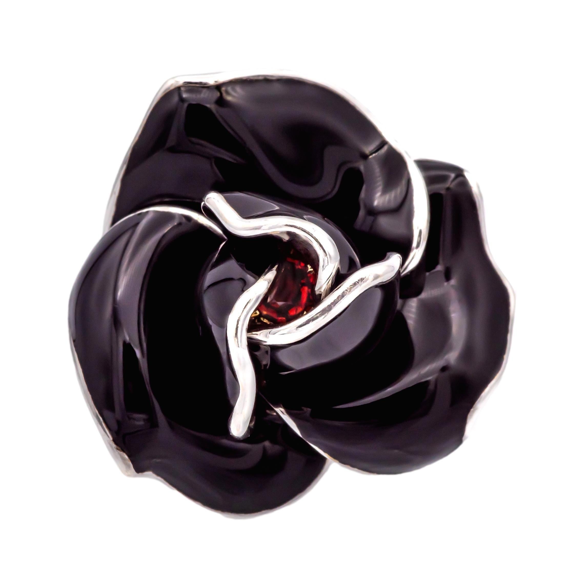 This Mia Nardi Rosa Ring from the Secret Garden Collection is a beautifully crafted piece in 18K white gold, forming a stunning rose motif. The black enamel petals move and open ever so slightly to reveal a hidden vibrant round orange sapphire at
