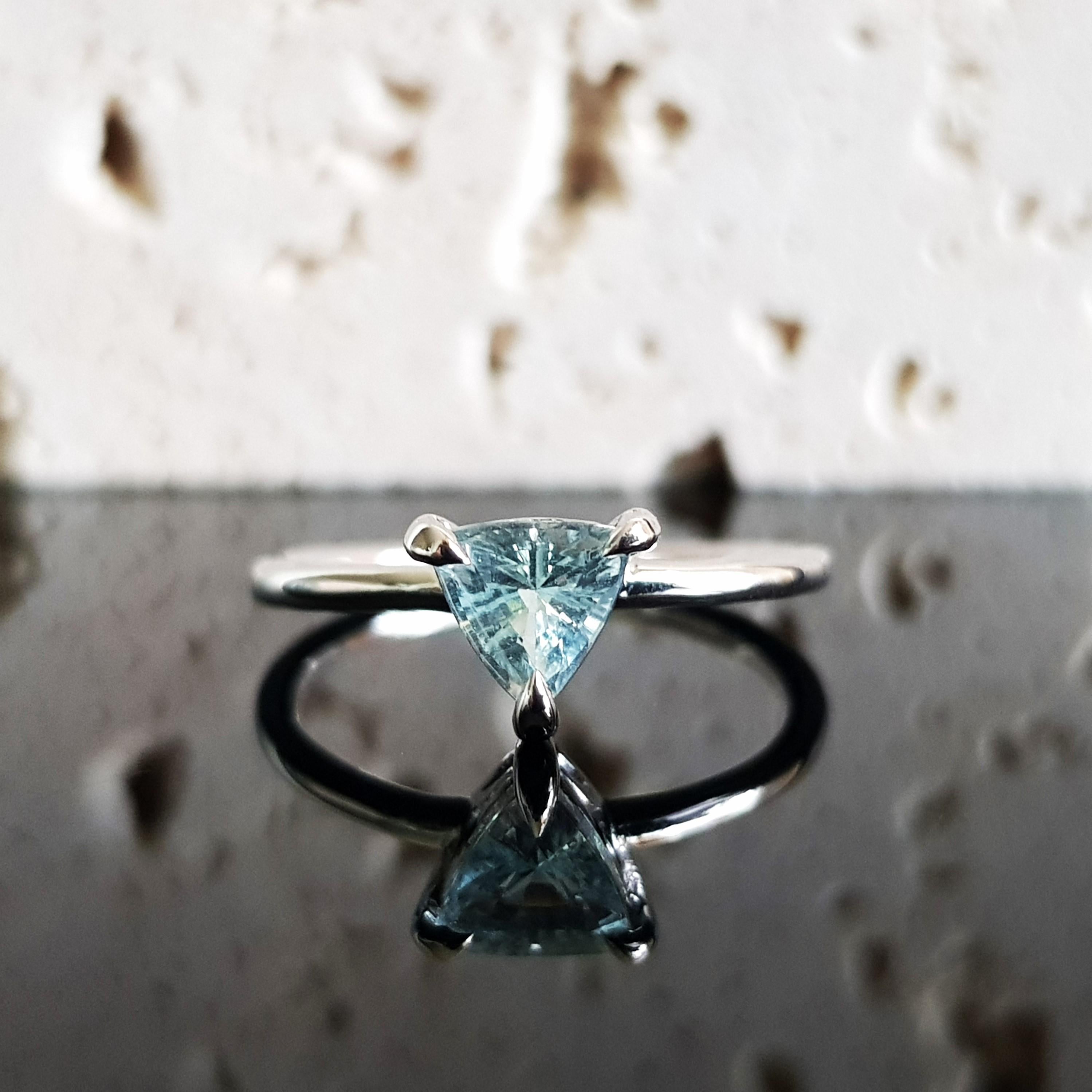 Dieser atemberaubende Trilogie-Ring aus Weißgold mit einem Aquamarin im Billionenschliff ist der Inbegriff von Luxus. Die kostbaren Edelsteine sind in Krallen gefasst, so dass ein Maximum an Licht durch die Steine dringt und die bezaubernden Farben