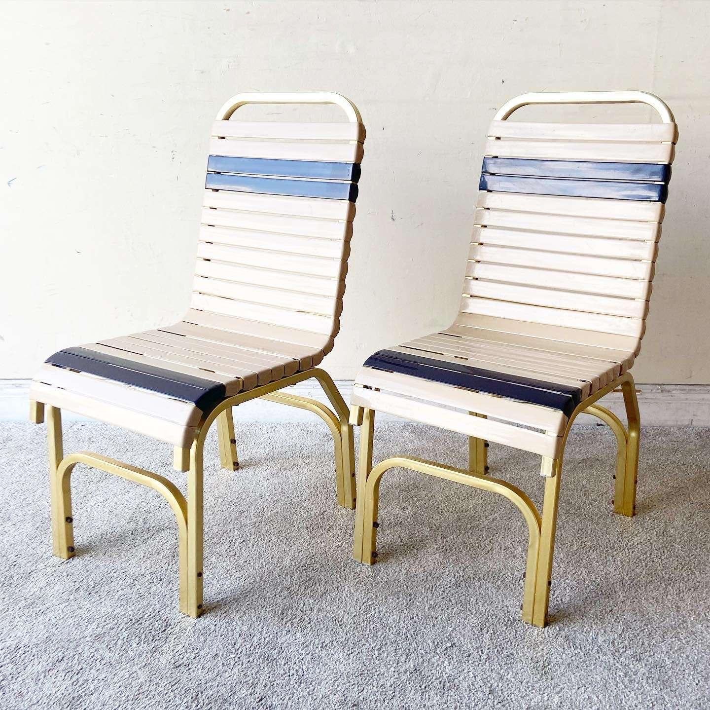Wonderful vintage mid century modern Miami poolside pair of chairs with table. The chairs and table have an aluminum metal frame. Table features a fiberglass top and chairs have rubber strap seat and back rests.