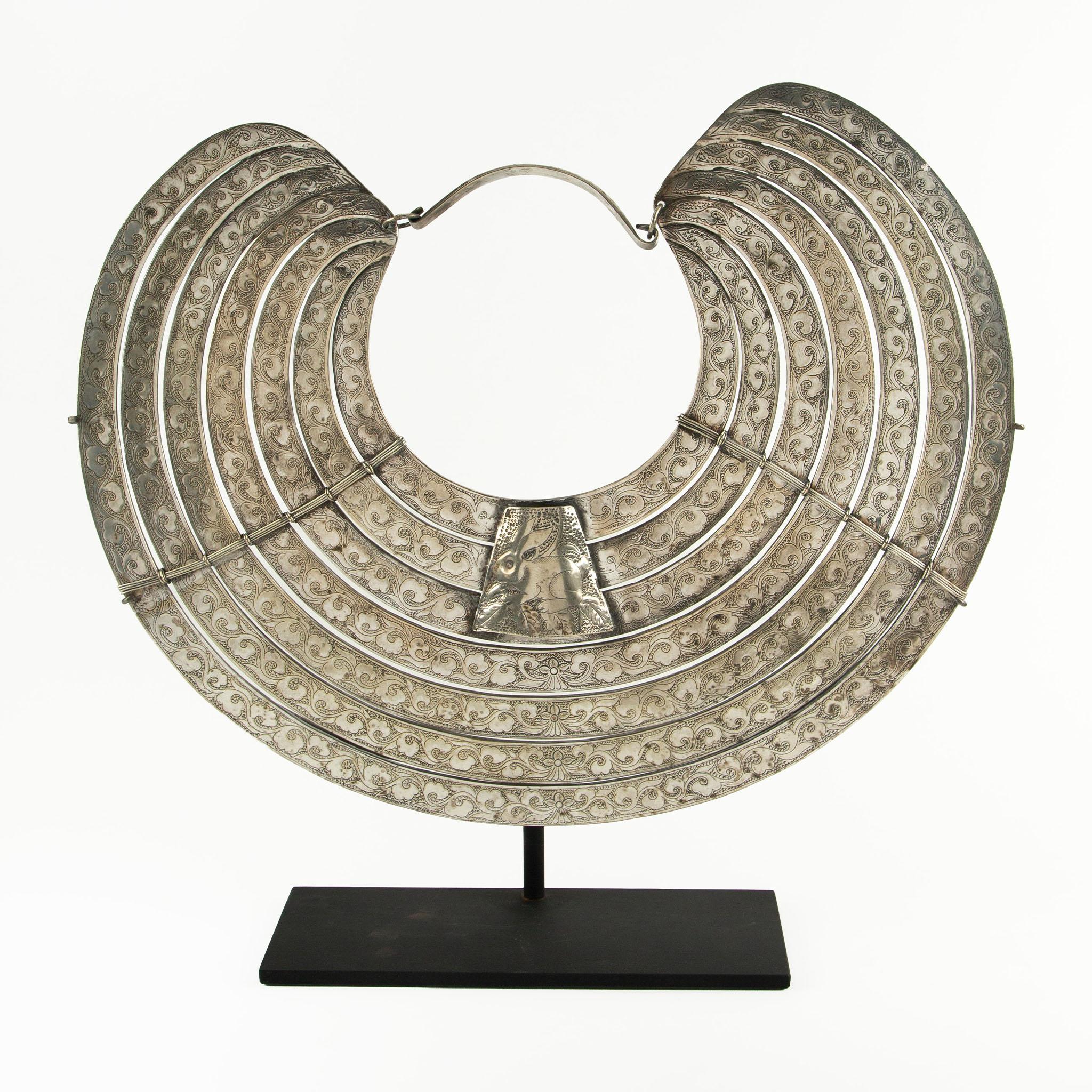 Exceptional multi-row silver pectoral torque, meticulously handcrafted by the Miao people, featuring eight graduated, crescent-shaped bands richly decorated with incised vegetal and floral scroll motifs in fine repoussé and chasing techniques. At
