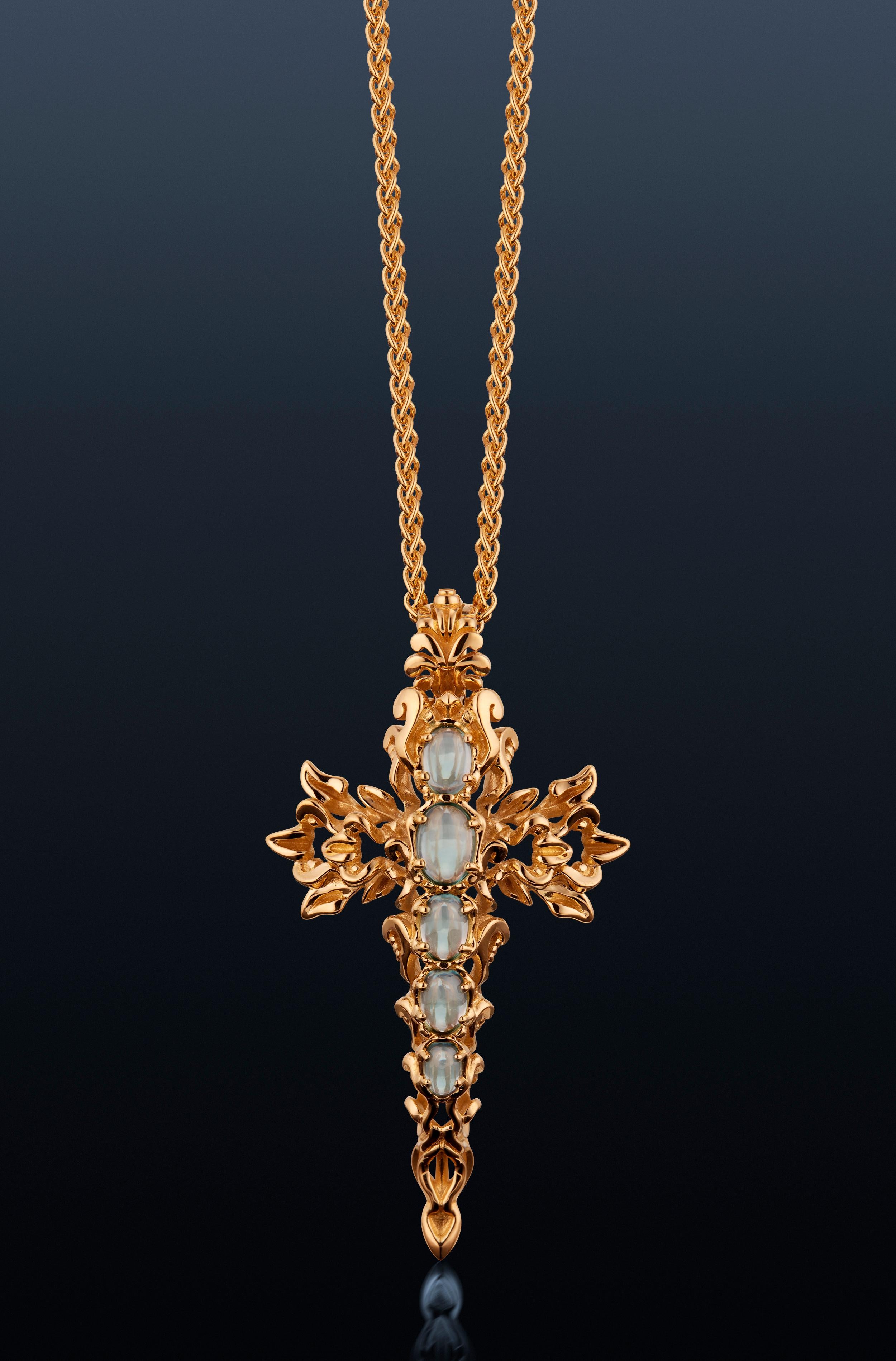 Le pendentif Croix de Verdure de Micah Antoni en or jaune 18 carats est un bijou sculptural qui incarne la force, la grâce et un art exceptionnel. Les vignes se tordent élégamment en une croix architecturale, ornée d'aigues-marines cabochons