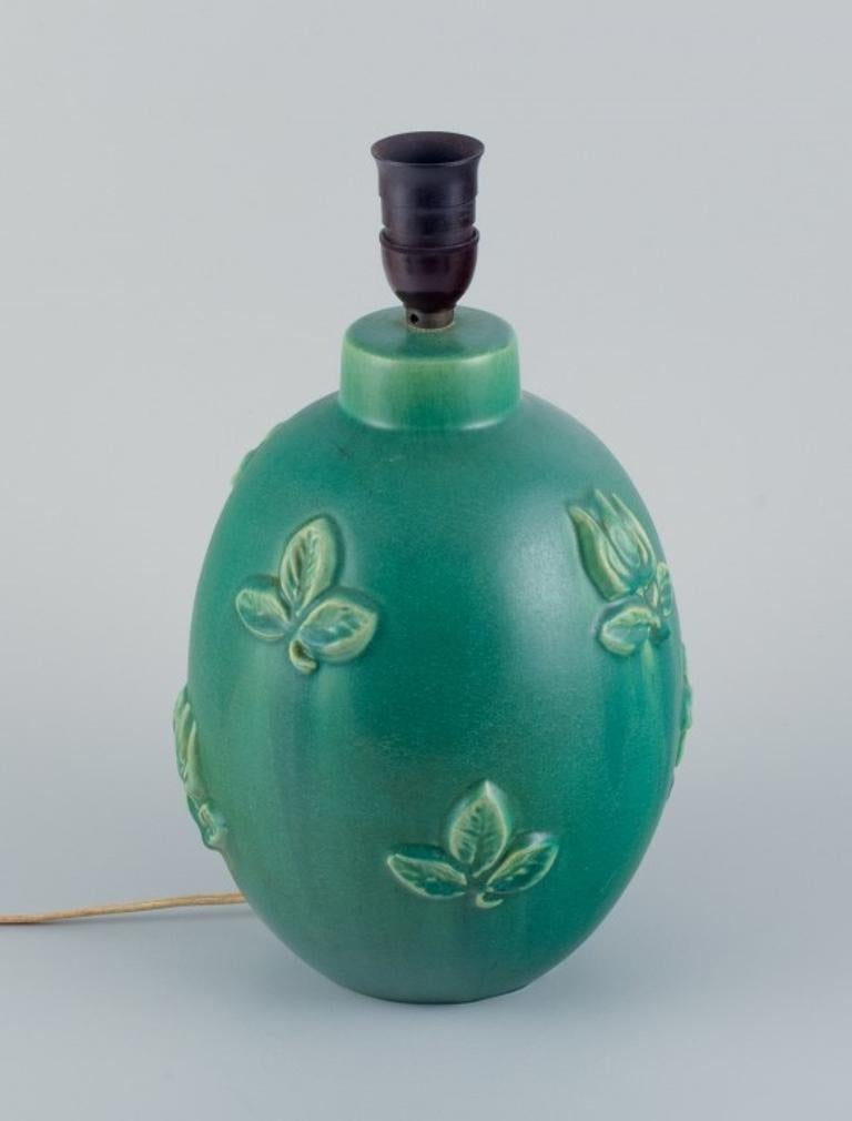 Michael Andersen (1859-1931), Bornholm, Denmark.
Large ceramic table lamp in shades of green with flowers and leaves in relief.
Approx. 1960s.
Small insignificant chip on the bottom.
In excellent condition.
Marked.
Dimensions: D 18.0 x 26.0 cm.