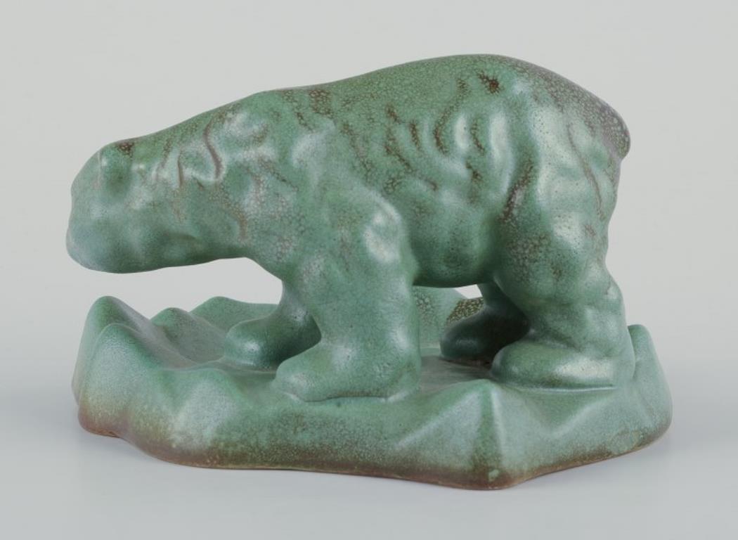 Michael Andersen (1859-1931), Bornholm. 
Keramikschale mit wandelndem Eisbären. 
Glasur in Braun- und Grüntönen.
Modell: 4055
Mitte des 19. Jahrhunderts.
Markiert.
Perfekter Zustand.
Abmessungen: B 14,0 cm. x H 8,5 cm.