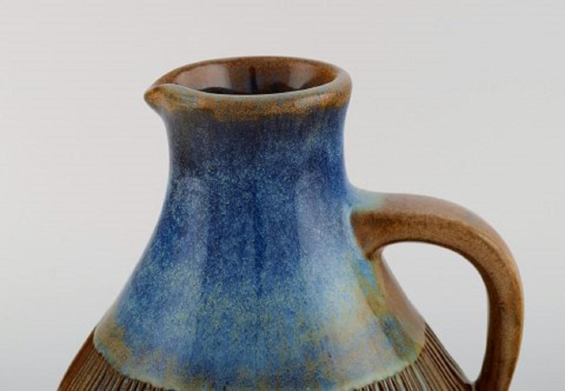Michael Andersen, Denmark. Large jug in glazed ceramics. Beautiful glaze in blue-brown tones, 1950s.
Measures: 20.5 x 18 cm.
In very good condition.
Stamped.