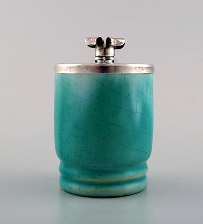 Michael Andersen, Denmark mustard jar in crackled ceramics with silver lid and silver spoon.
Turquoise glaze. Silverco silver lid. Cohr, Denmark silver spoon.
Measures 8.5 cm x 6 cm. (incl. lid)
In good condition.