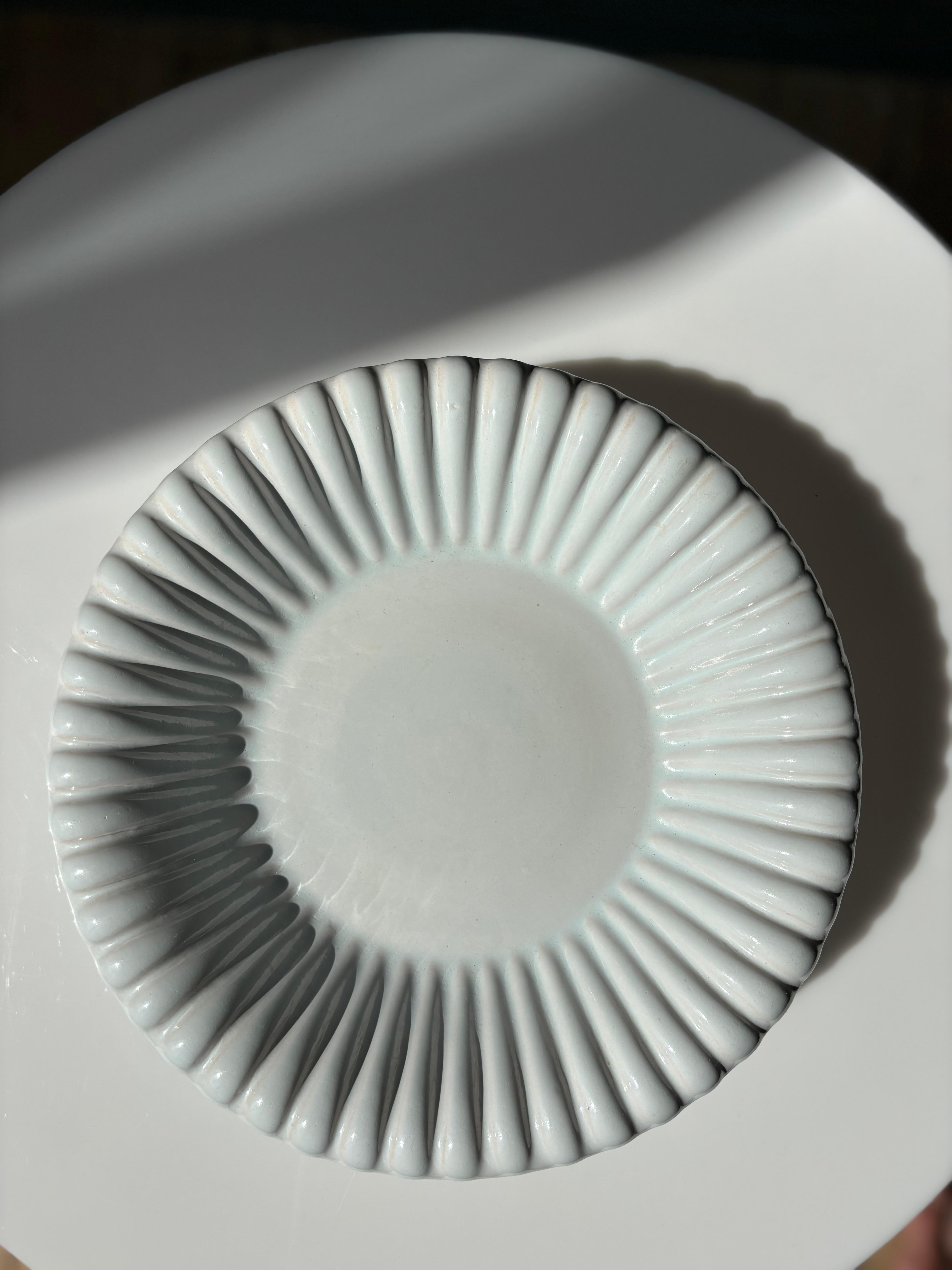 Handmade Danish midcentury modern decorative dish bowl designed and manufactured on the island of Bornholm by Michael Andersen & Son in the early 1960s. Crisp white glaze with a very slight light blue tint covers the bowl’s round shape and soft