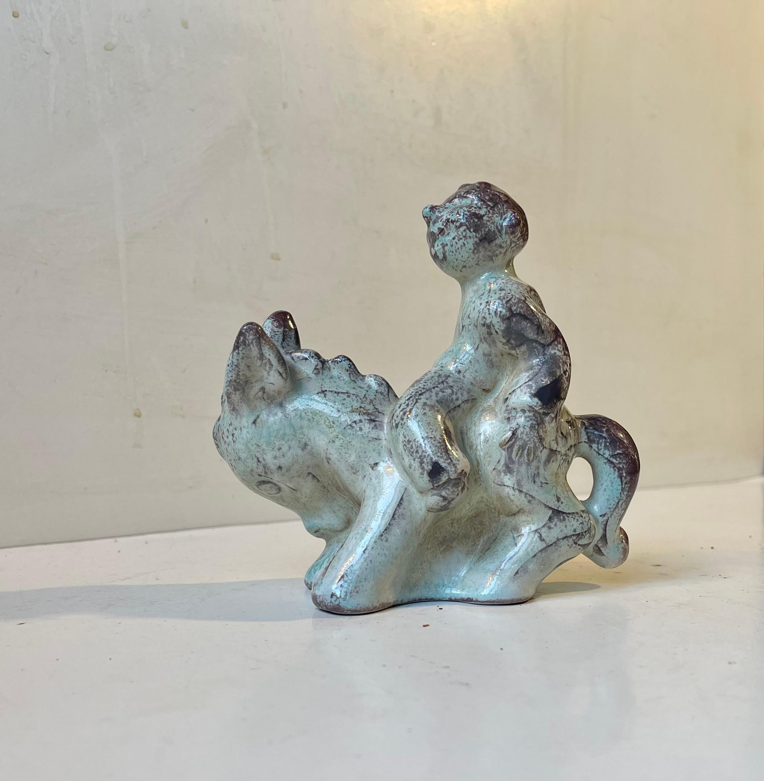Rare figurine en céramique de Michael Anderssen exécutée avec la glaçure Perse. Elle représente un garçon sur un âne et est probablement une allégorie de la laideur, de l'entêtement, de l'excitation, etc. Il porte la marque de l'écusson de MA&S et