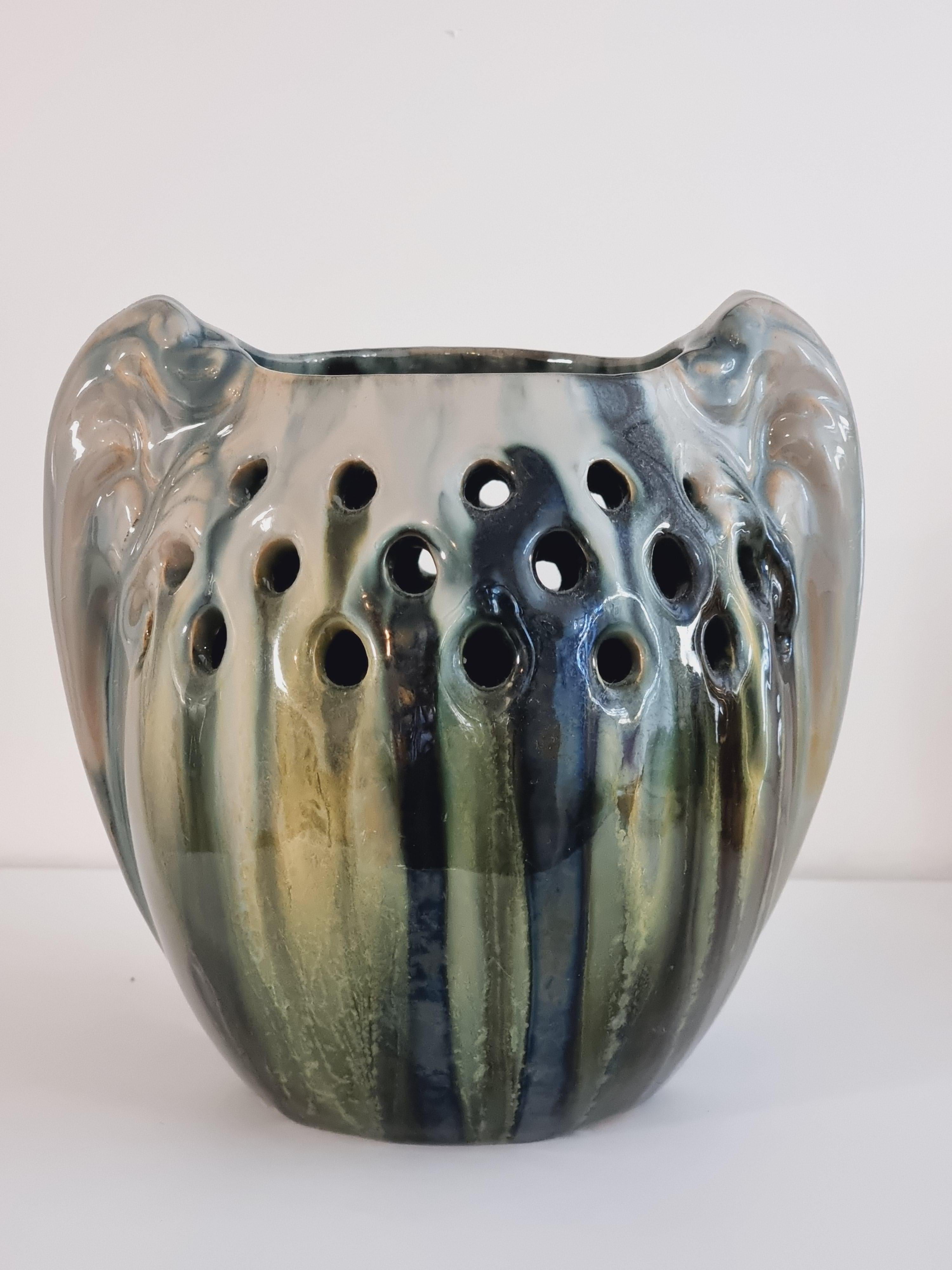 Rare, decorative vase by Michael Andersen & Son (MA&S) with beautiful glaze in different colors (yellow, green, grey..) flows down the rounded shape. 

The upper part has decorative shapes of perforation/holes and the sides has beautiful winged
